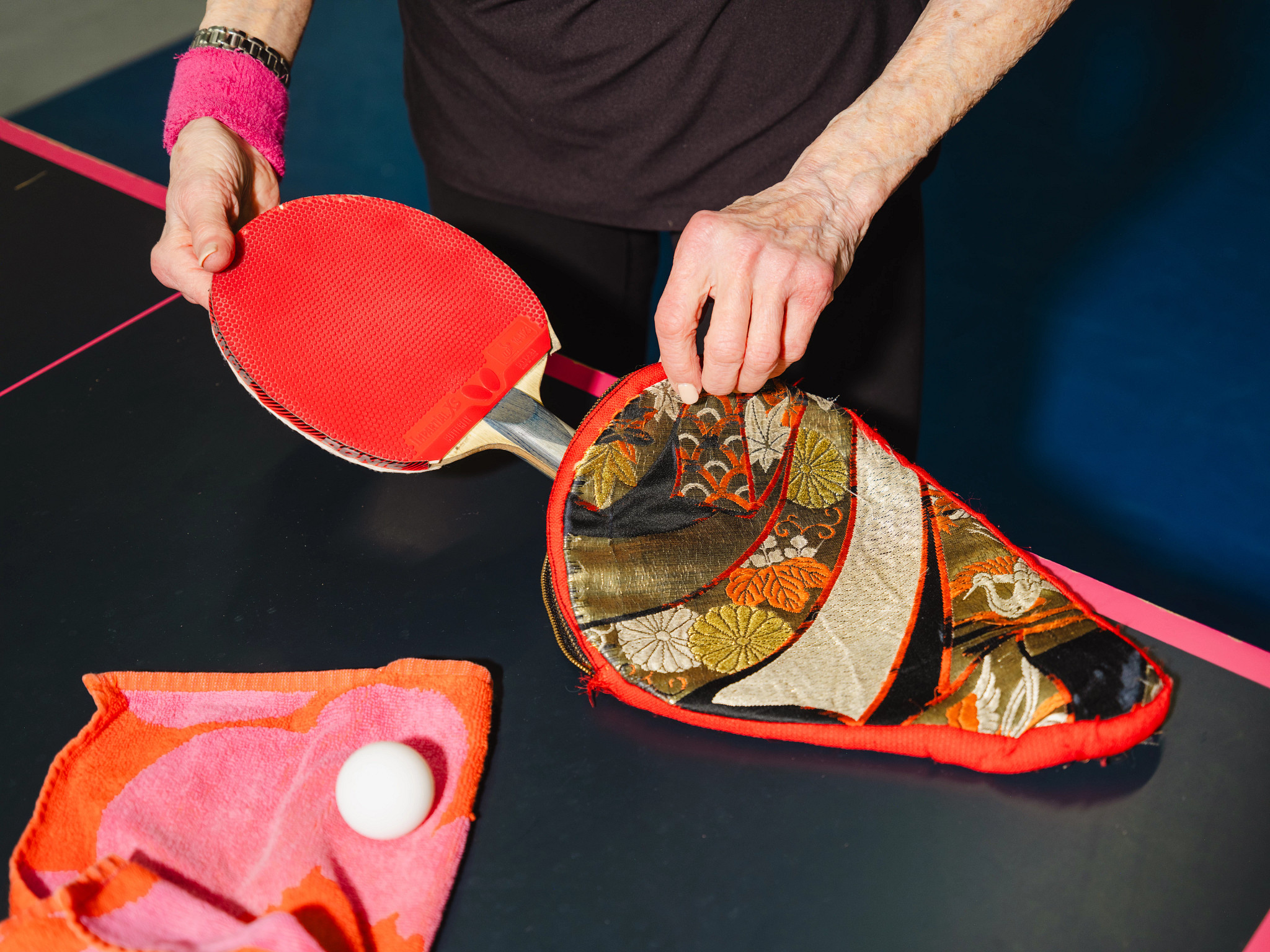 Carol Klenfner packs her ping pong gear into a custom-embroidered case with flower designs