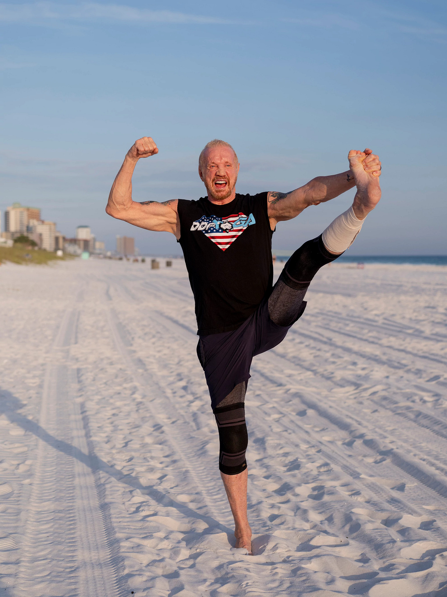 a photo shows diamond dallas page doing yoga at the beach