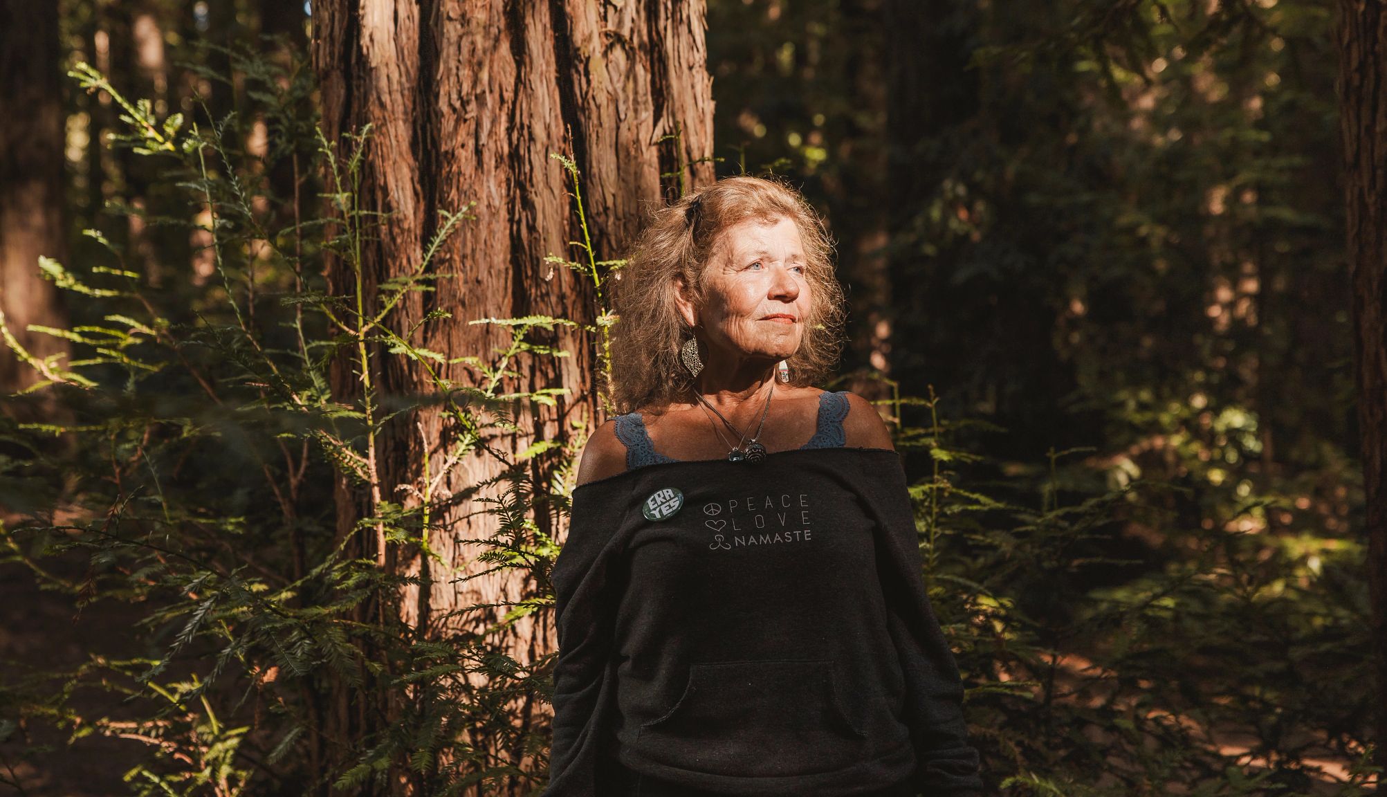 A photograph of Elizabeth Schenk in the woods