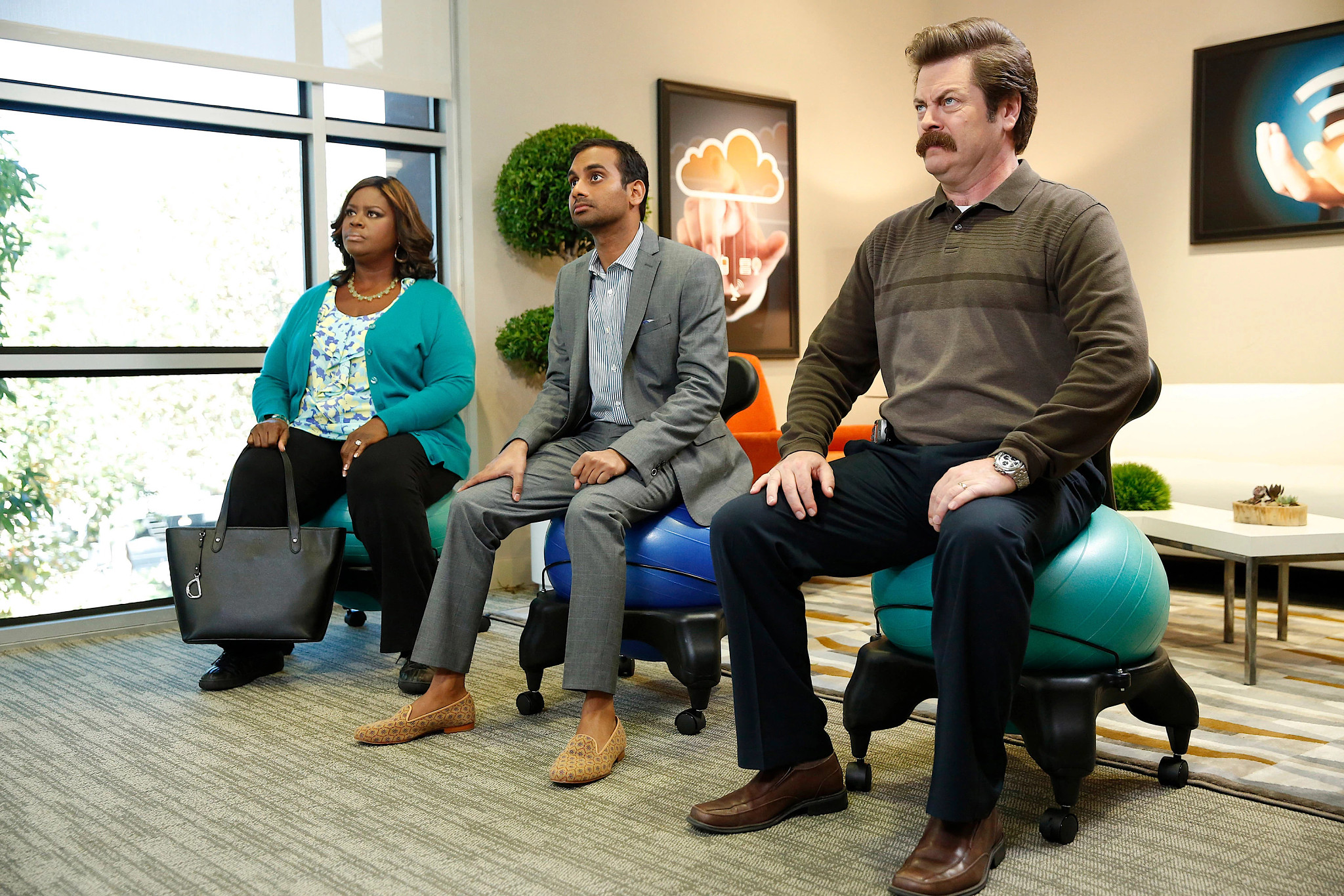 Retta, Aziz Ansari and Nick Offerman sitting on exercise balls in a still from Parks and Recreation