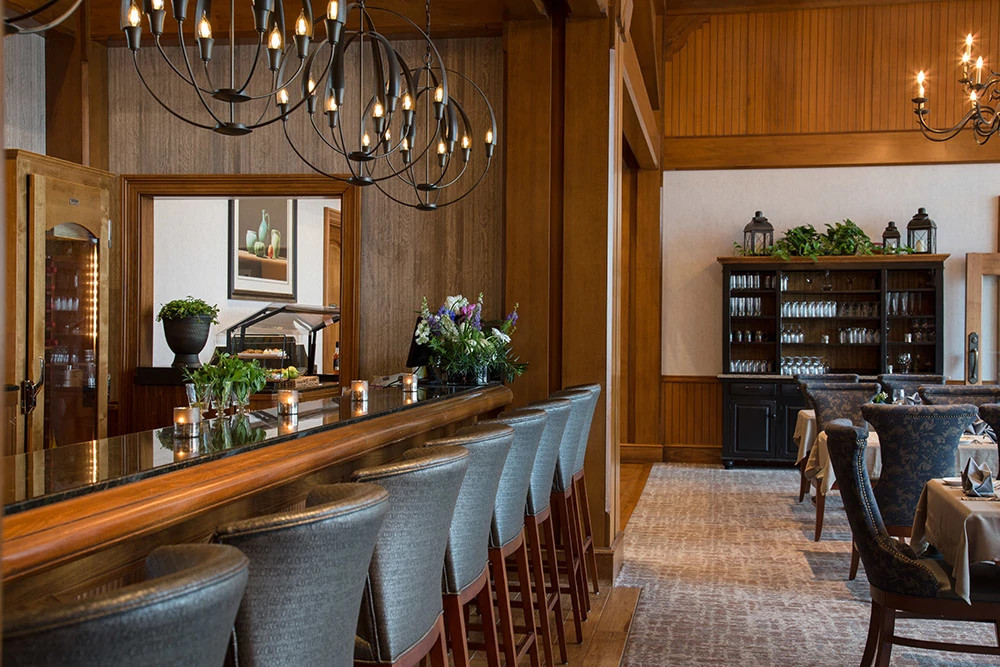 Upscale spa dining room with wood paneling and modern chandeliers at a wellness retreat