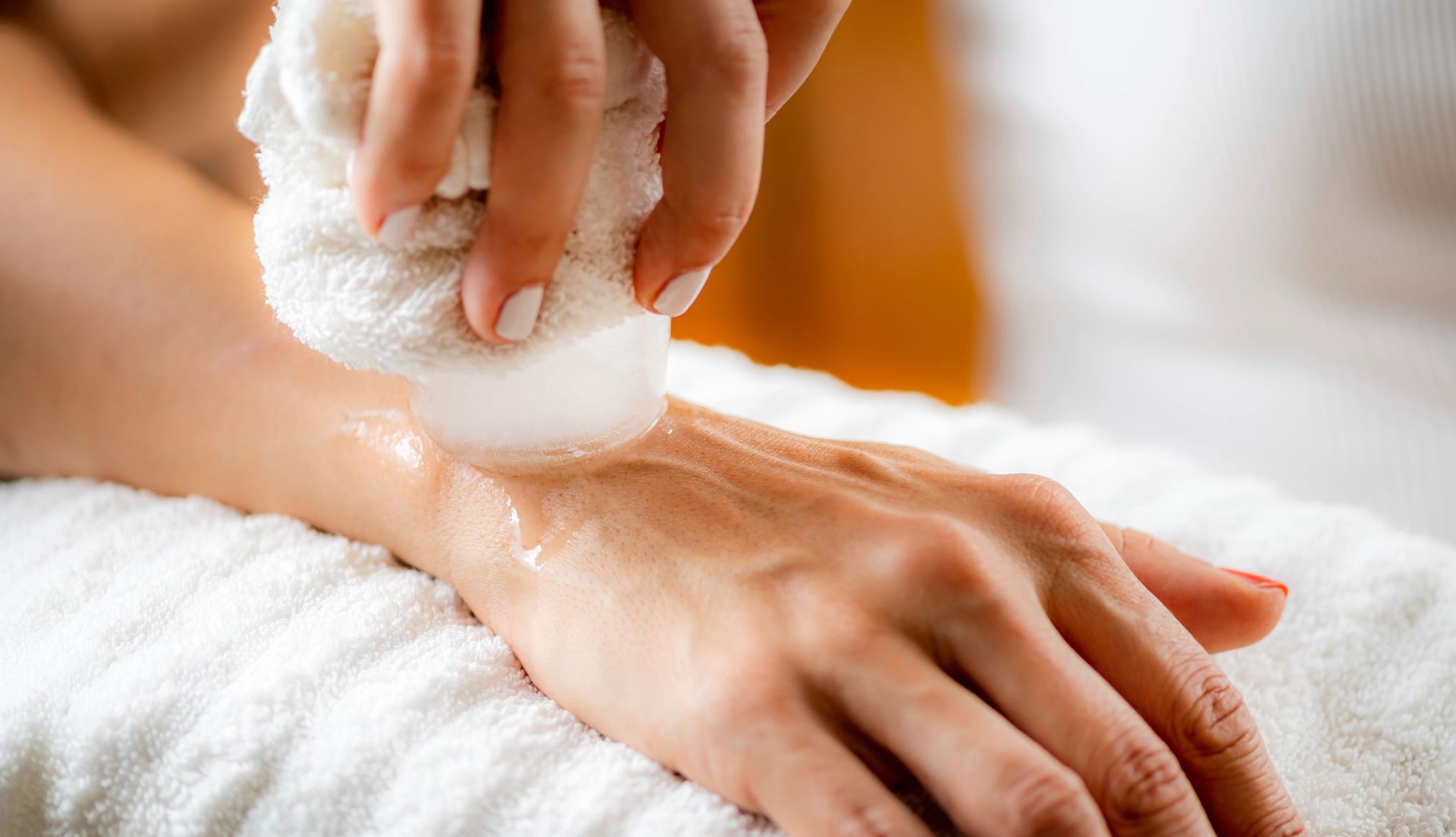 Joint Pain and Menopause woman rubbing ice on her wrist