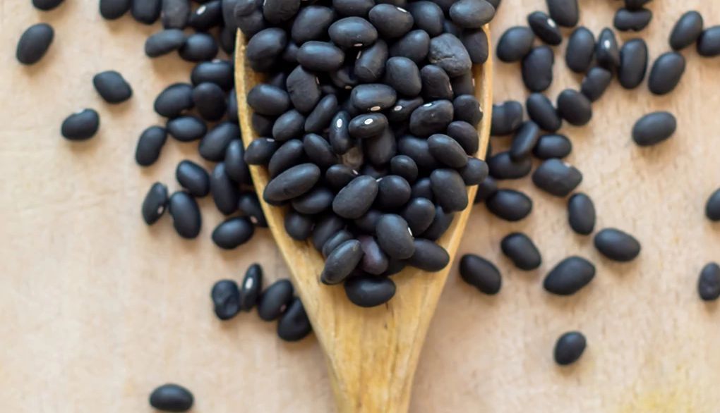 Beans are packed with protein, fiber and B vitamins An up-close view of black beans on a wooden spoon
