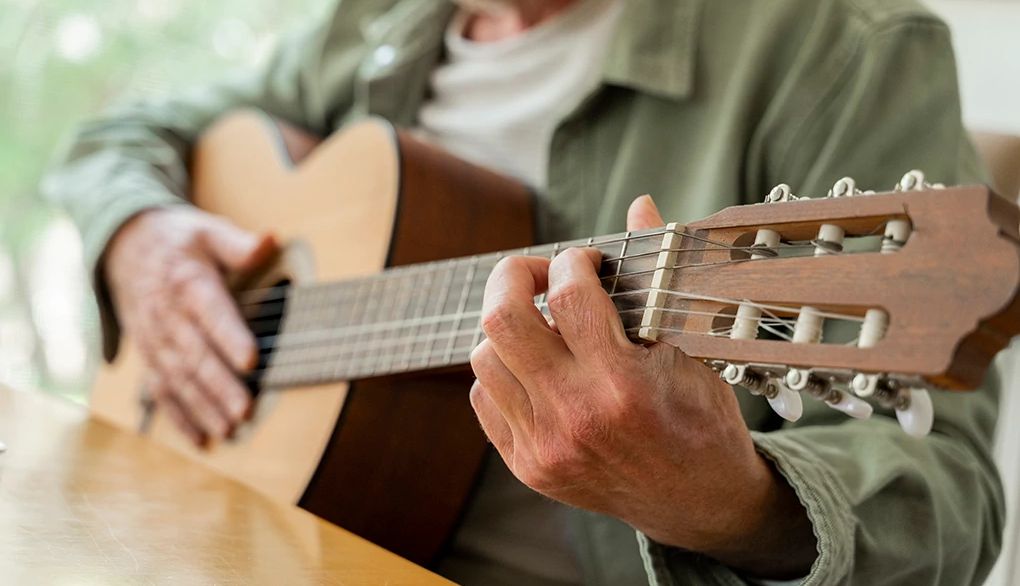 Learning music after age 50 can stimulate the brain A close-up view of a man playing a guitar