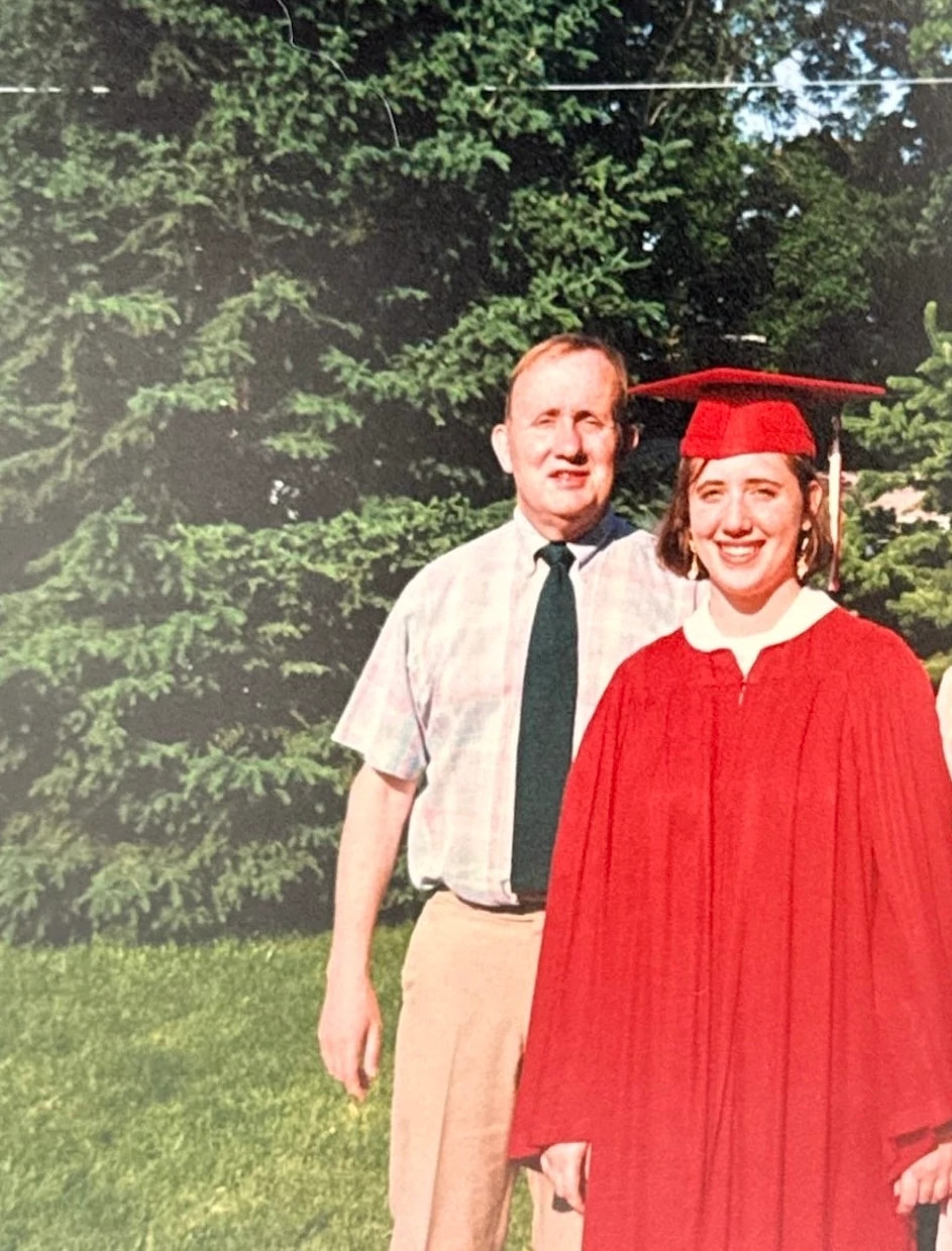 a photo shows Author Amy Carlson Gustafson and her father posed together at her high school graduation in 1993.