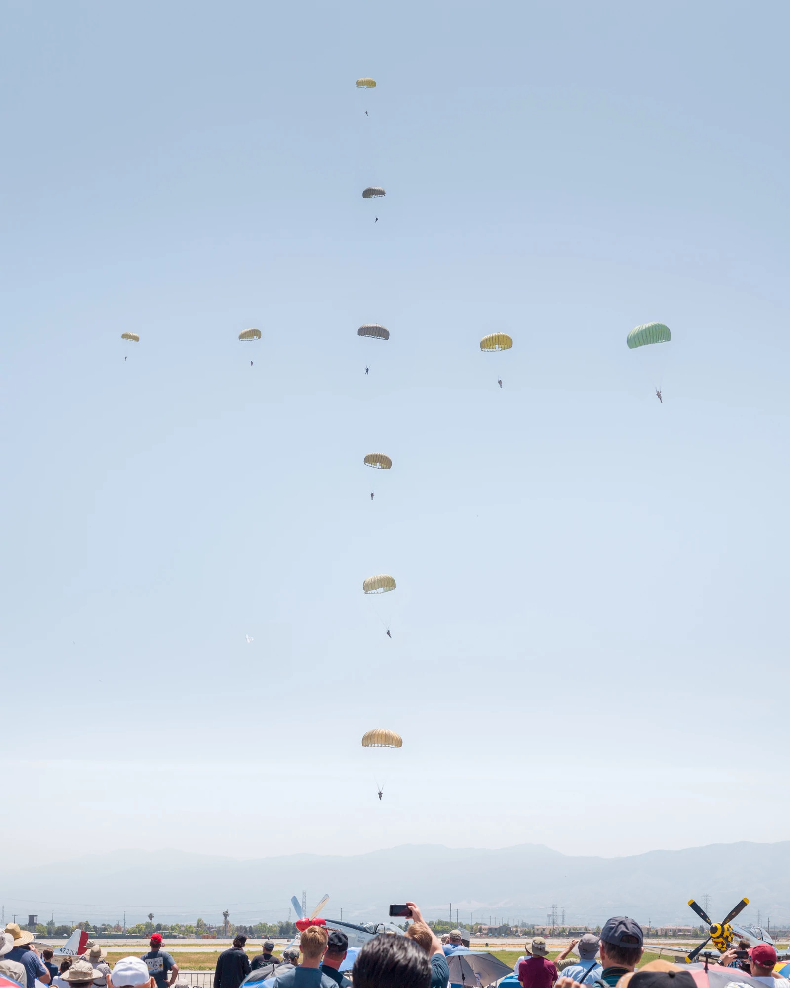 a crowd watches a parachute demonstration