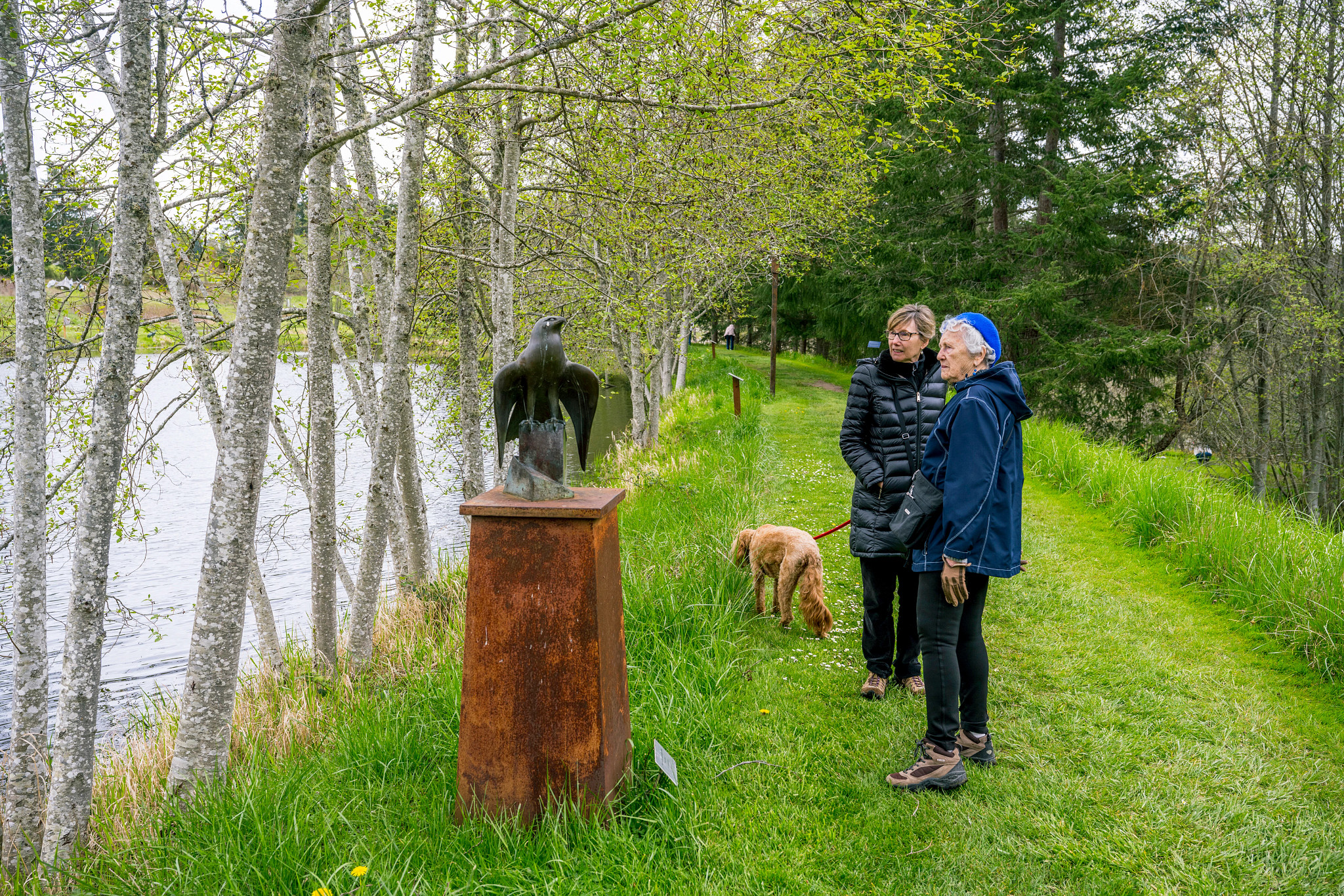 people looking at a sculpture at a park