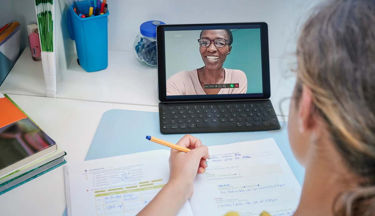 Kid being tutored virtually by a smiling woman