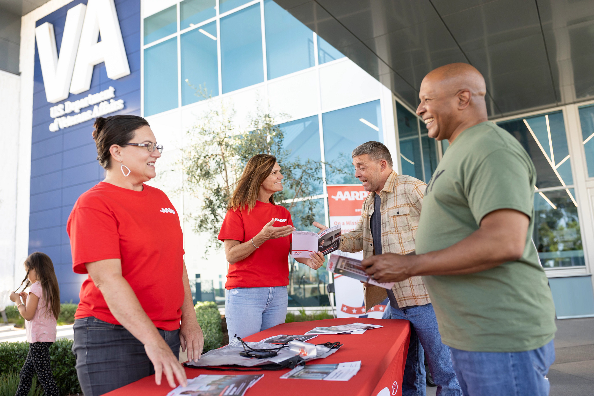 volunteers meet with two veterans outside of a veterans affairs medical facility
