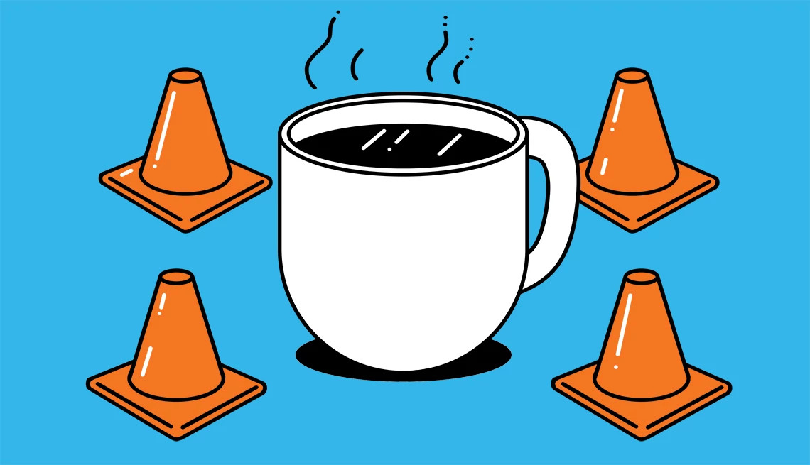 a cup of coffee surrounded by white traffic cones