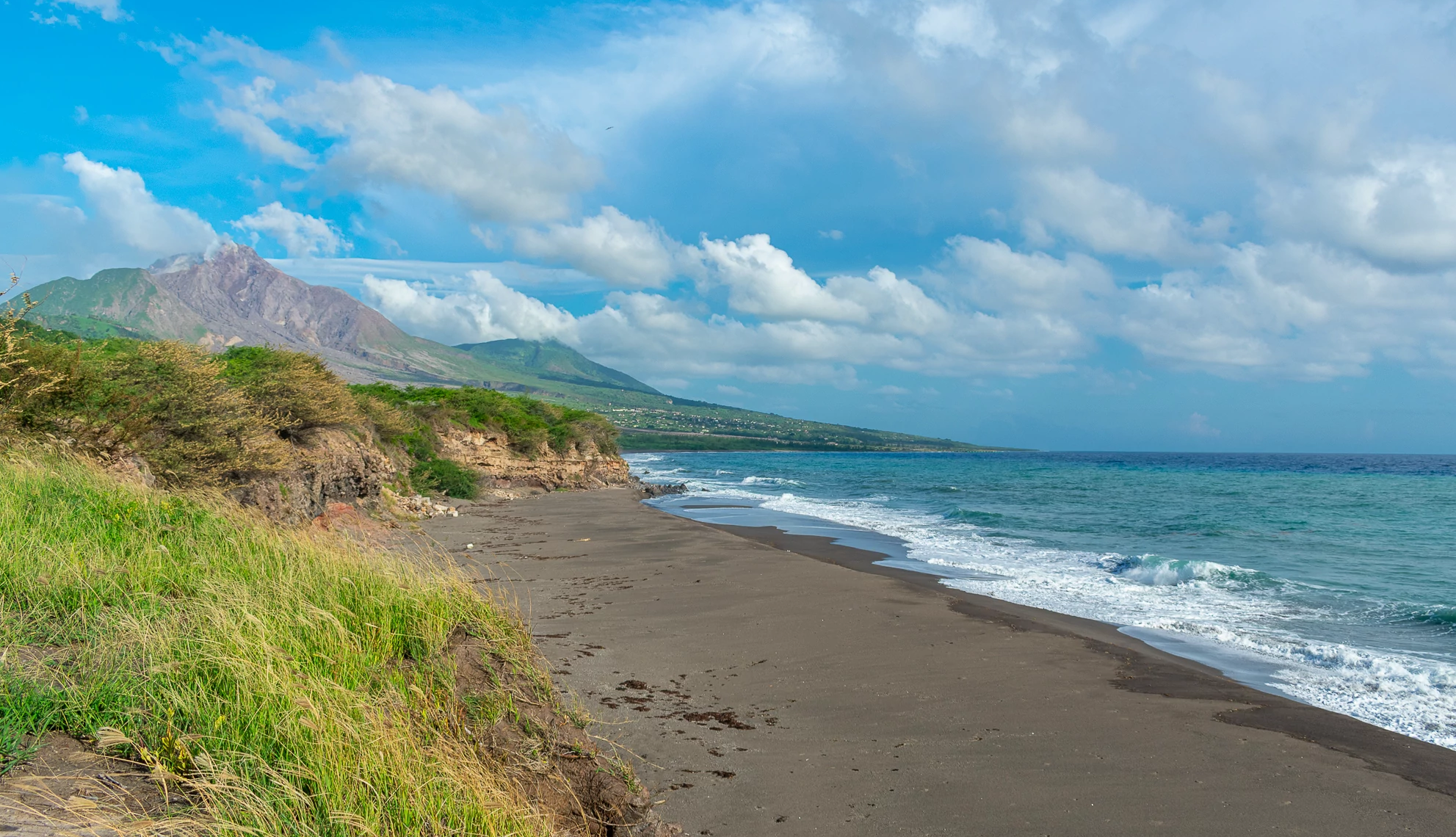 Quiet Caribbean Beaches an empty beach with mountains in the background