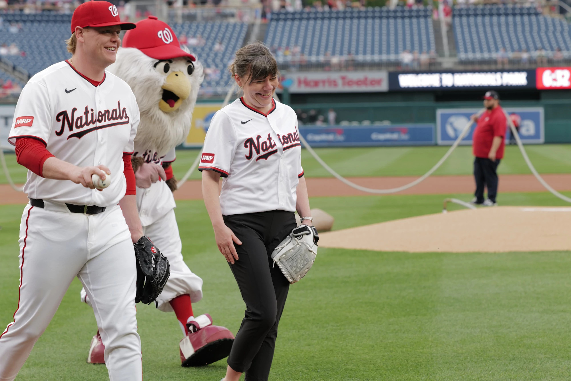 a photo shows Claire Casey, president of AARP Foundation, throwing the first pitch 