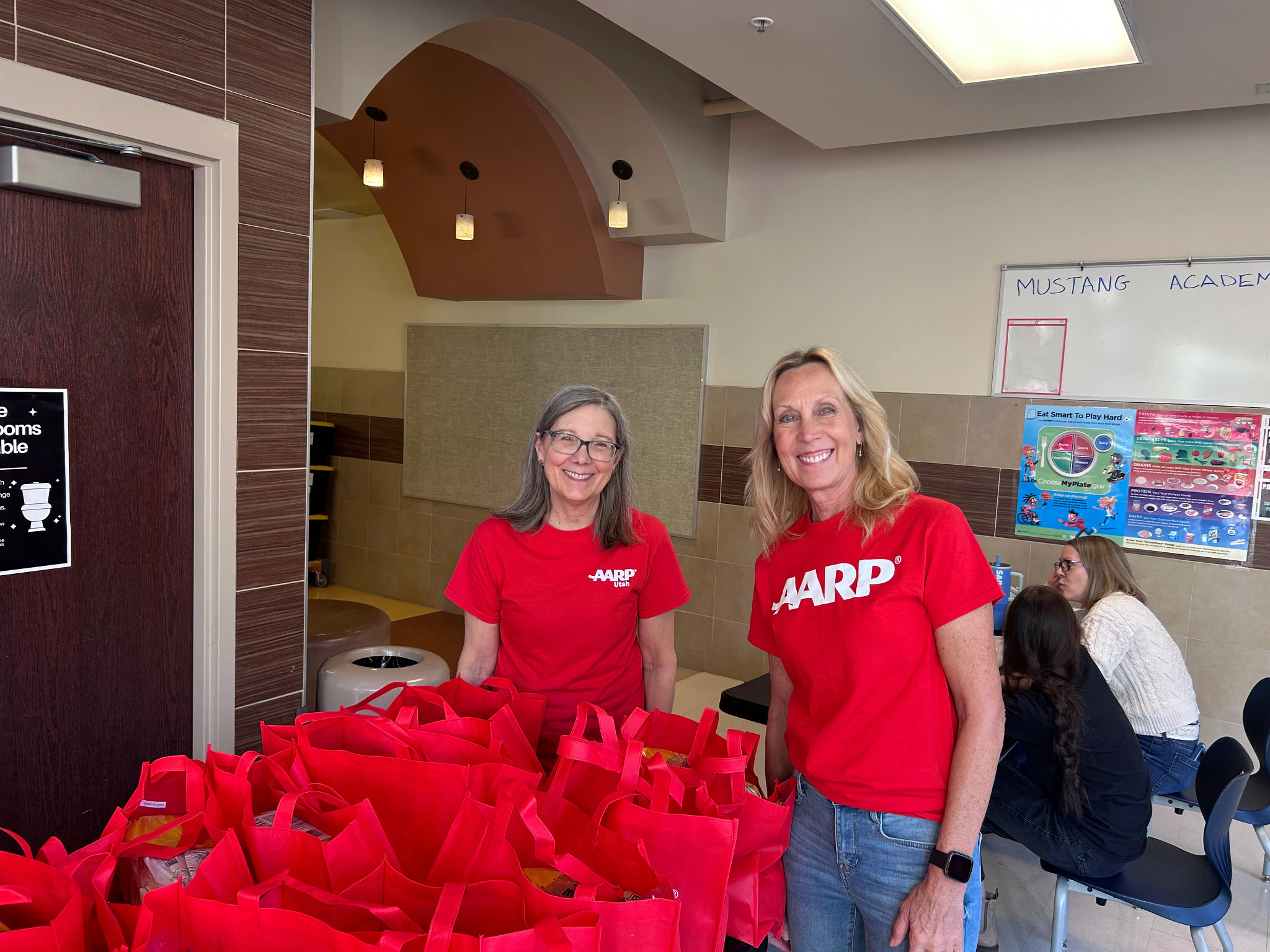 AARP Volunteers taking photo by bags of food