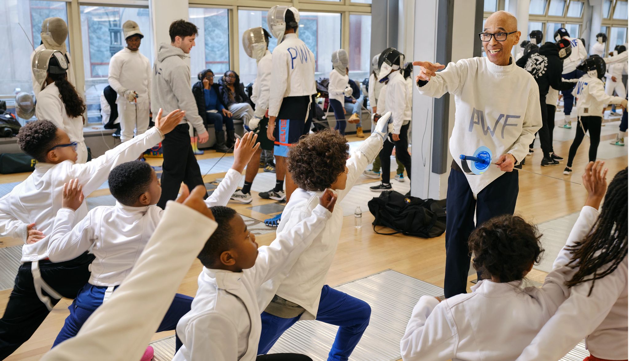 Peter Westbrook teaches fencing Peter Westbrook pointing towards group of kids who are doing a fencing move