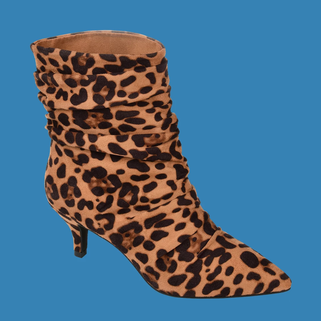Leopard-print ankle boots with kitten heels and pointed toes against a bright blue background
