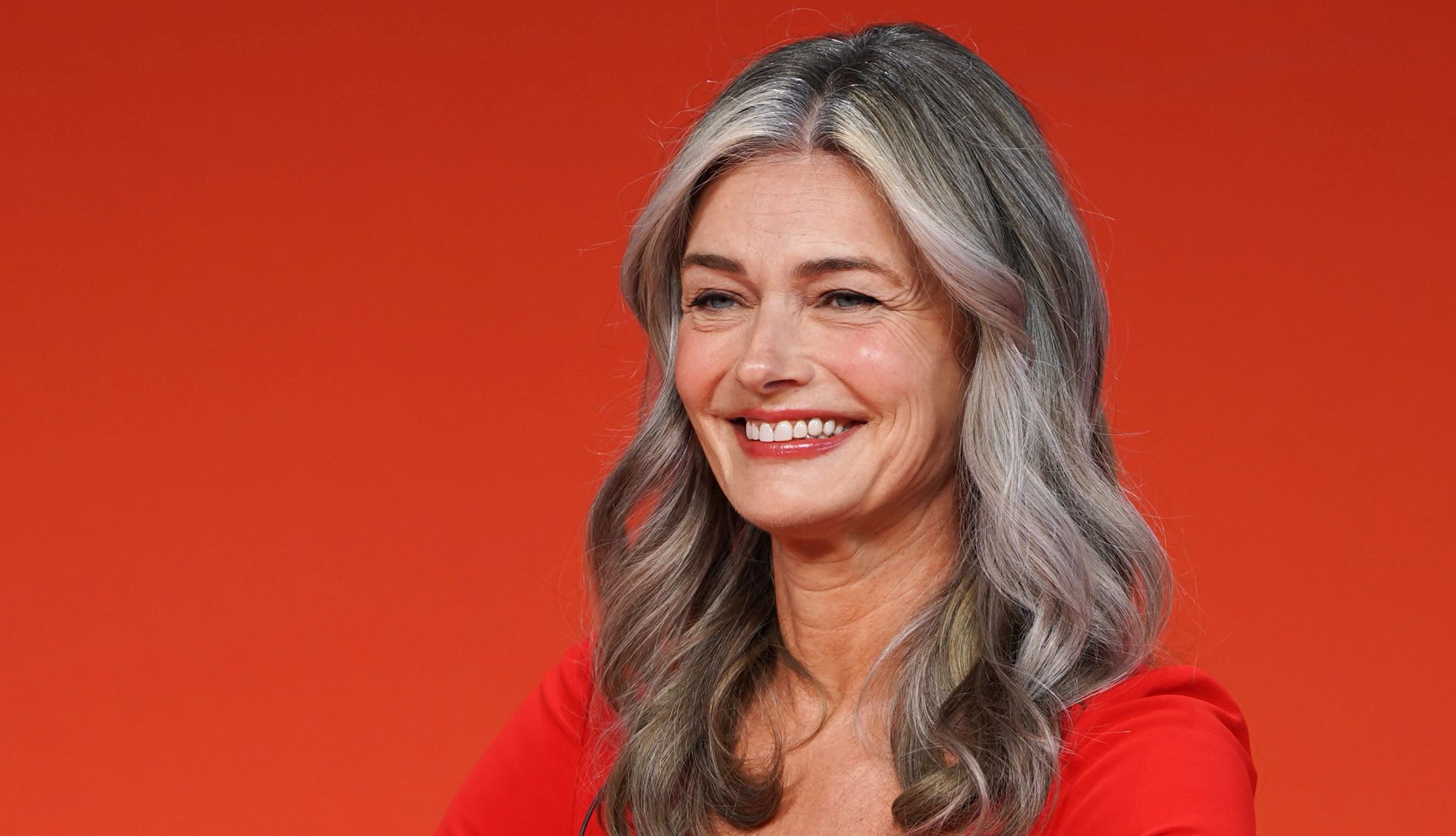 Paulina Porizkova Reflects on Aging paulina porizkova smiling in front of a red background