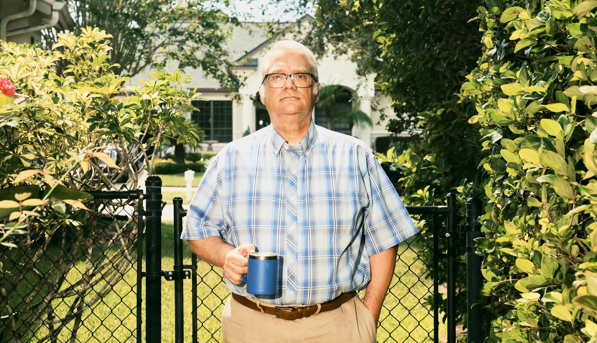 Gen X Fears for Social Security a man holds a mug in front of his home, surrounded by greenery