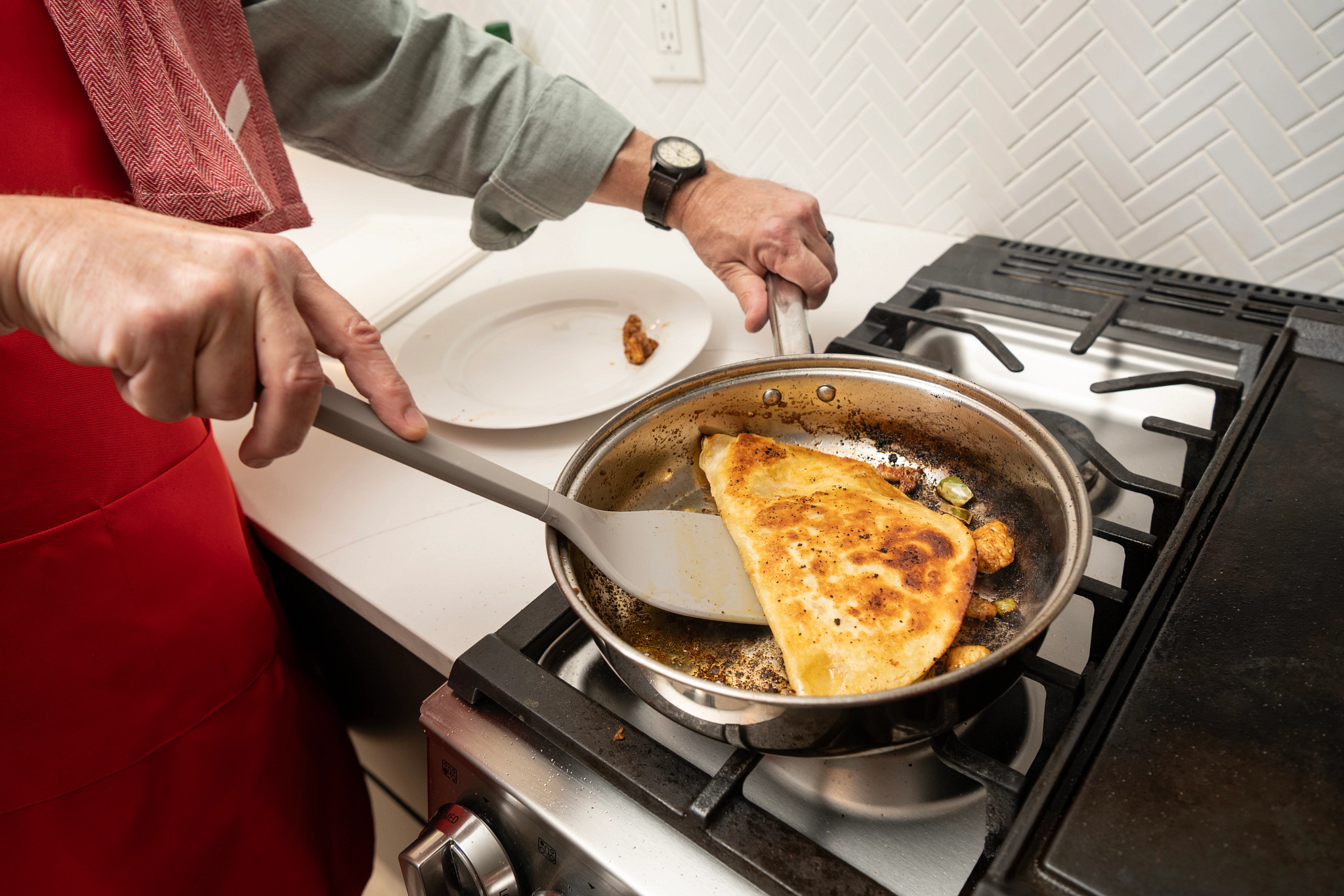 A man flipping a quesadilla from his EveryPlate meal in a pan on the stovetop