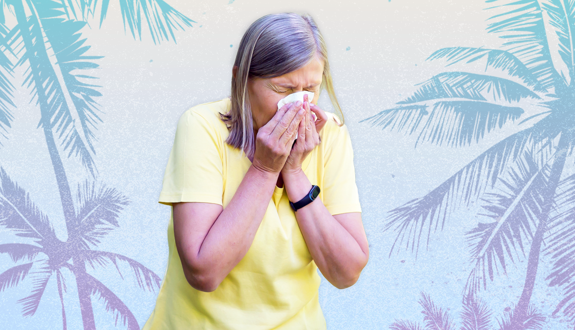 woman in yellow shirt sneezing on a tropical background