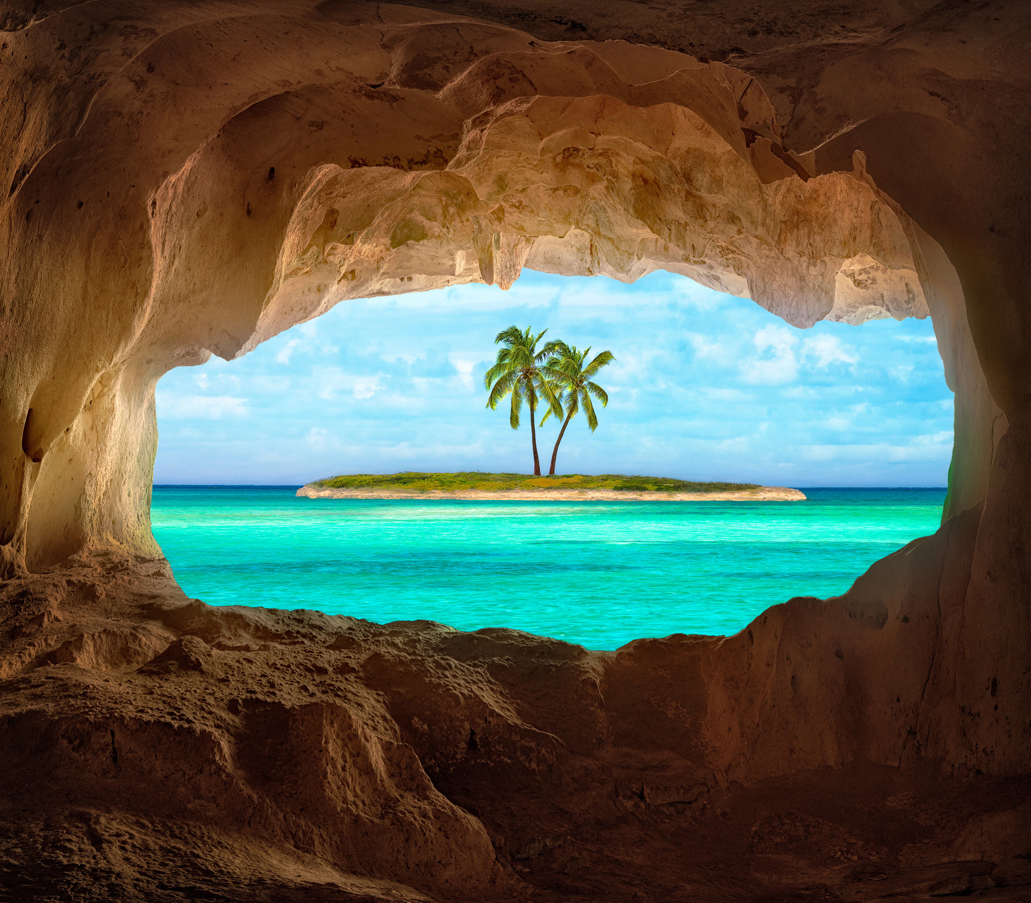 An old Indian cave located on a remote Caribbean Island. Beautiful Caribbean sea glowing and warm sunlight bathing some remote coconut palm trees on a deserted island