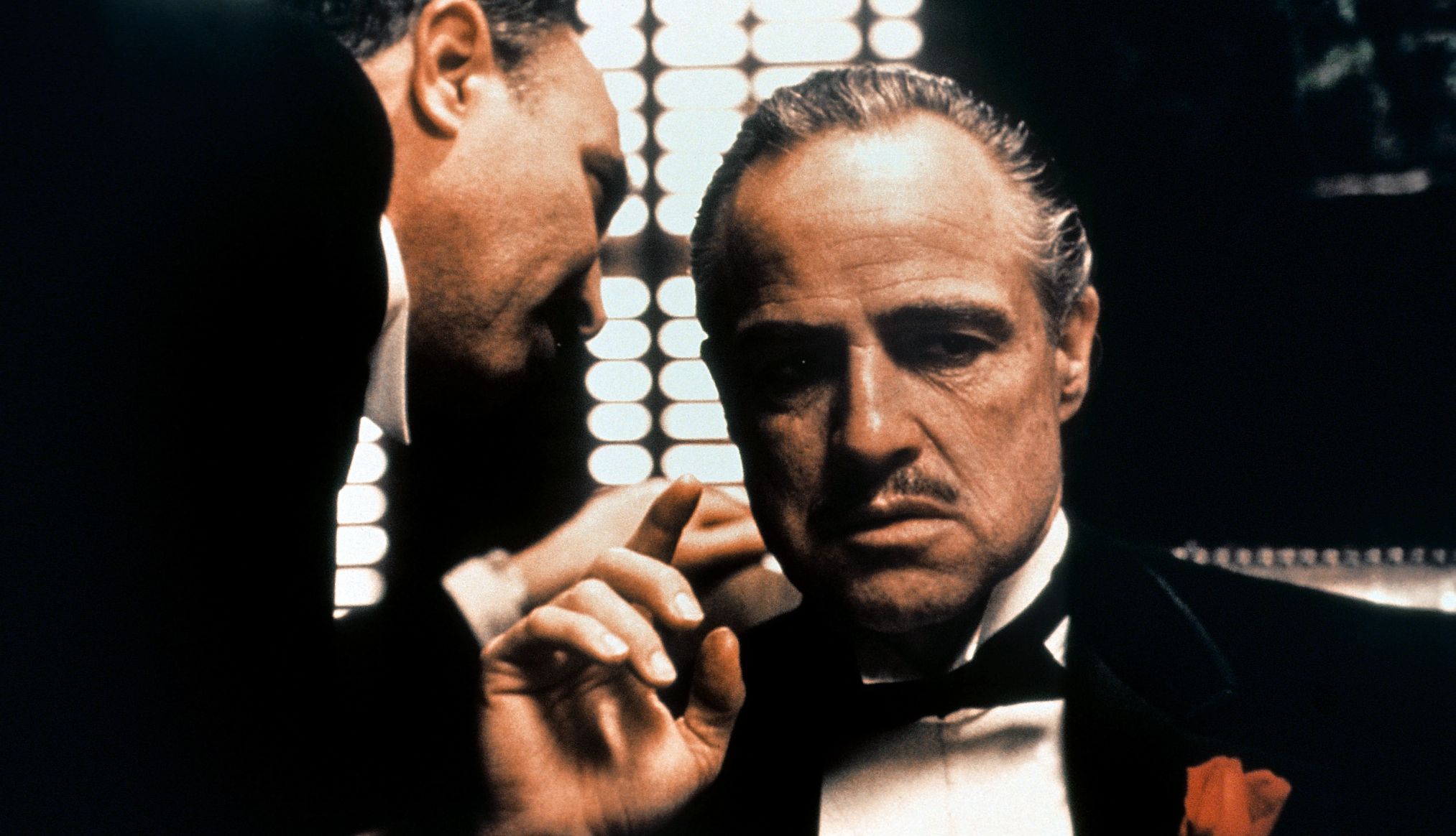 The Godfather Salvatore Corsitto speaking into Marlon Brando's ear in the film The Godfather