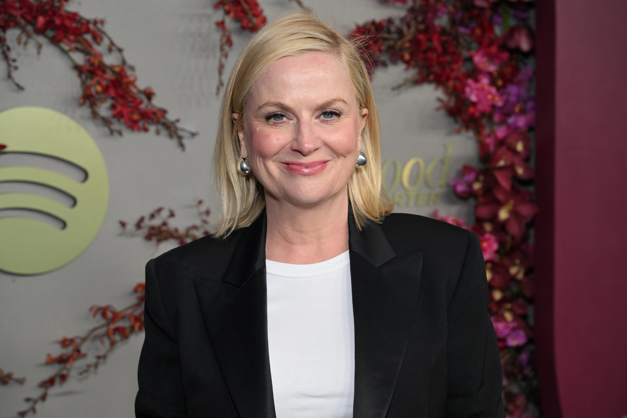 Amy Poehler smiling, wearing a black blazer