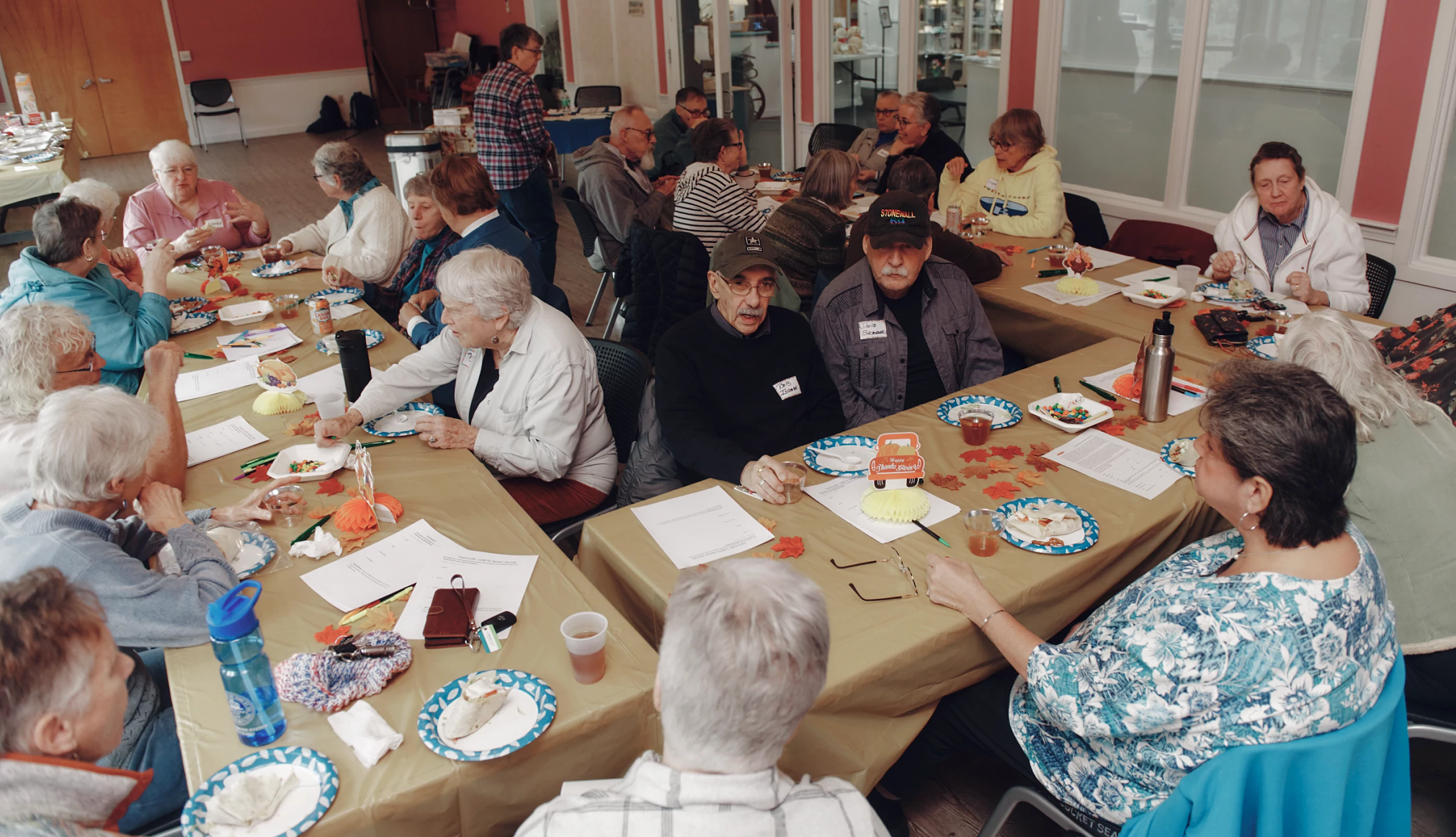 LGBTQ+ Older Adults Find Safe Spaces at Senior Centers a group of seniors sitting around tables
