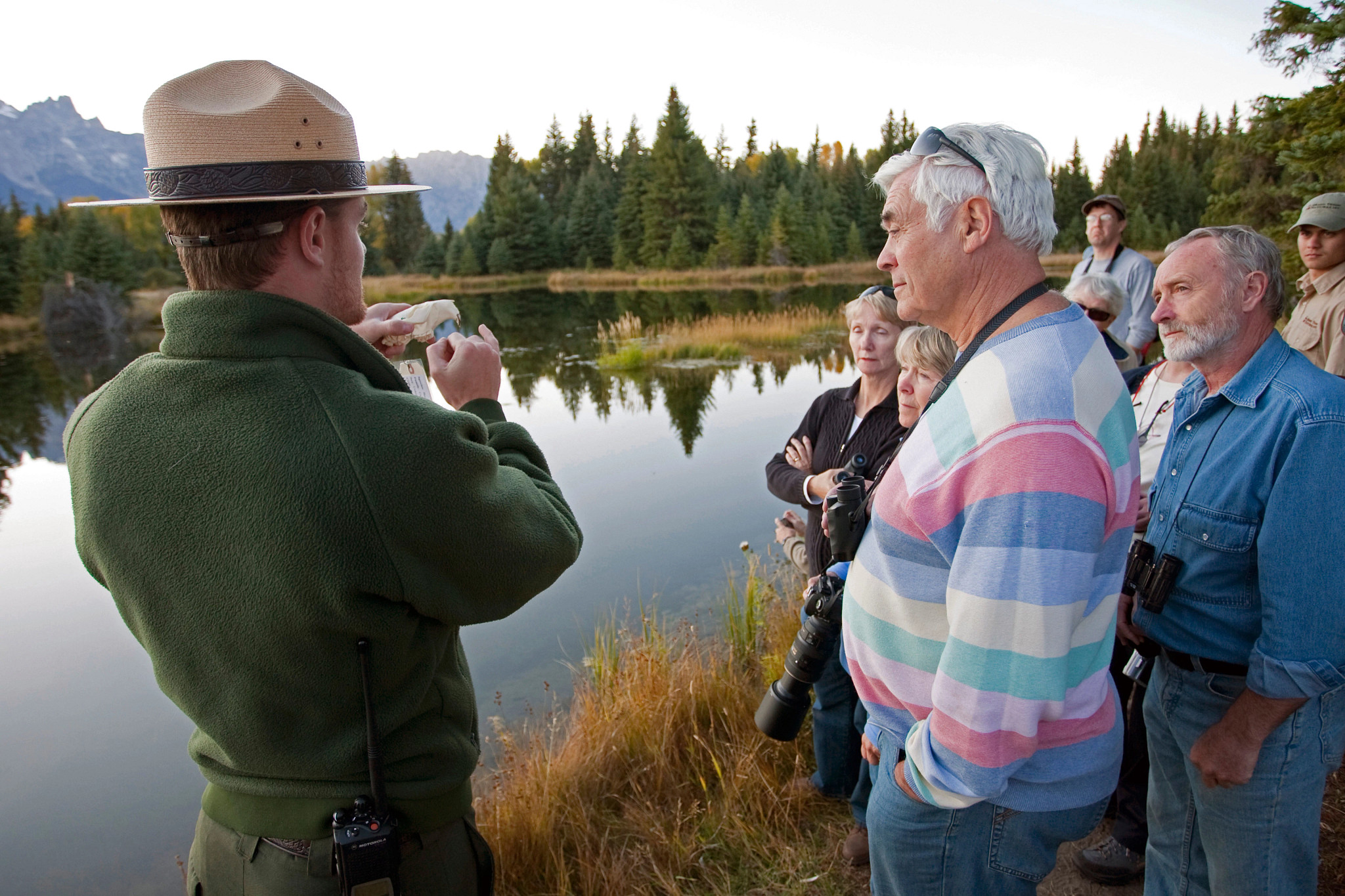 a park ranger talking to a group near a lake