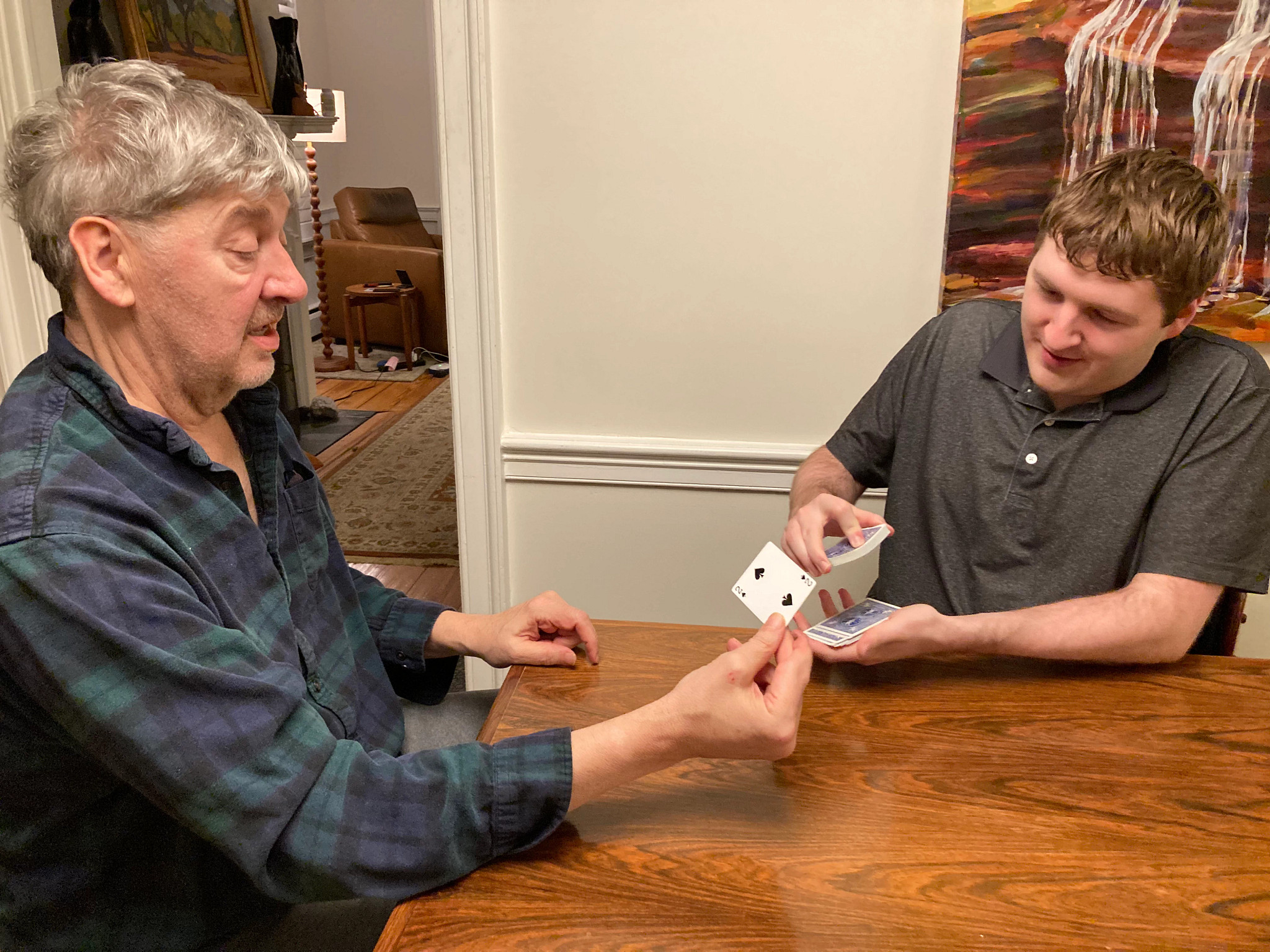 a photo shows Jim O’Connell and son William practicing a card trick.