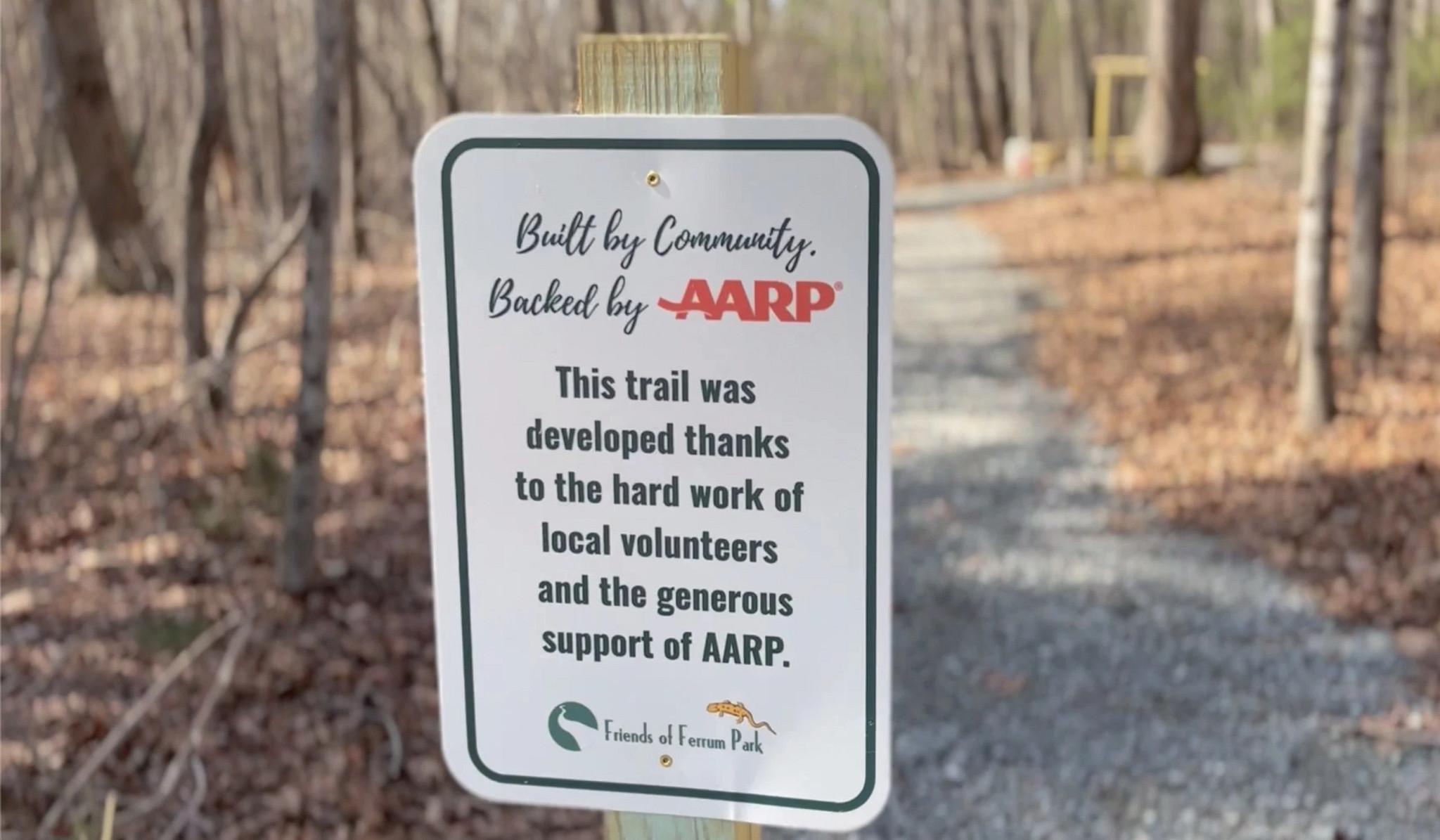 Park sign for Ferrum Park reading Built by Community. Backed by AARP This trail was developed thanks to the hard work of local volunteers and the generous support of aarp