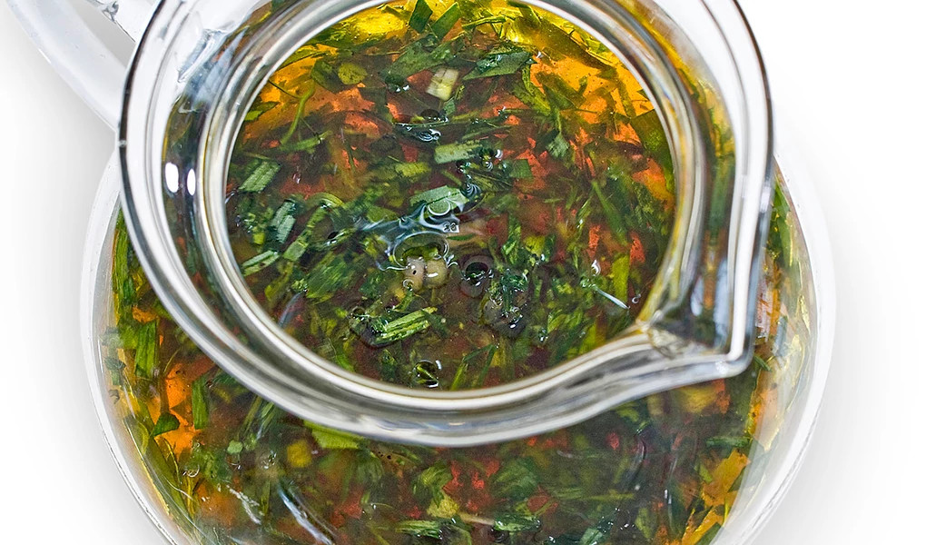 A close-up view of herb vinaigrette in a pitcher