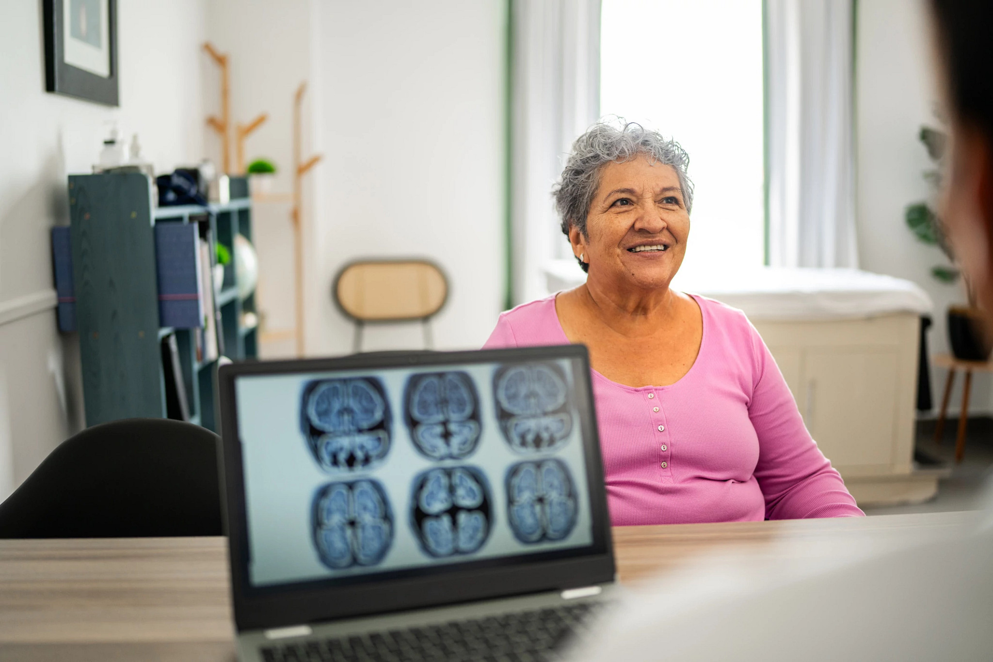 senior woman talking to doctor during consultation at hospital