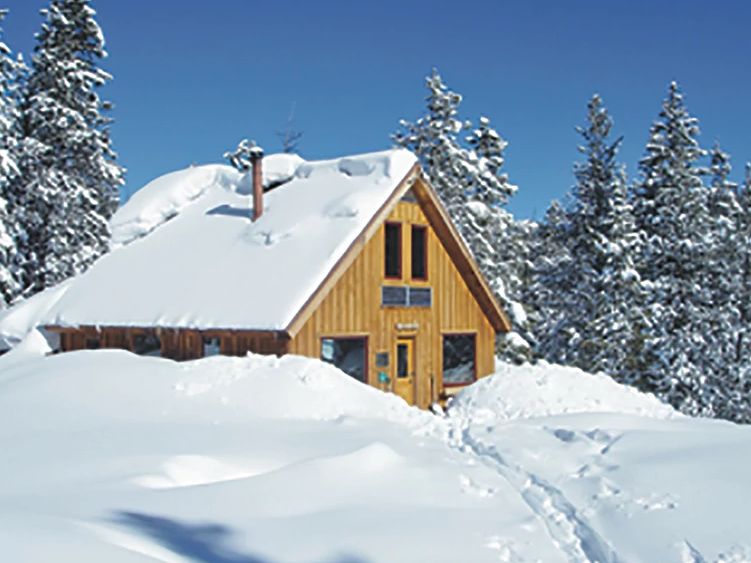 Cabaña en las montañas con nieve
