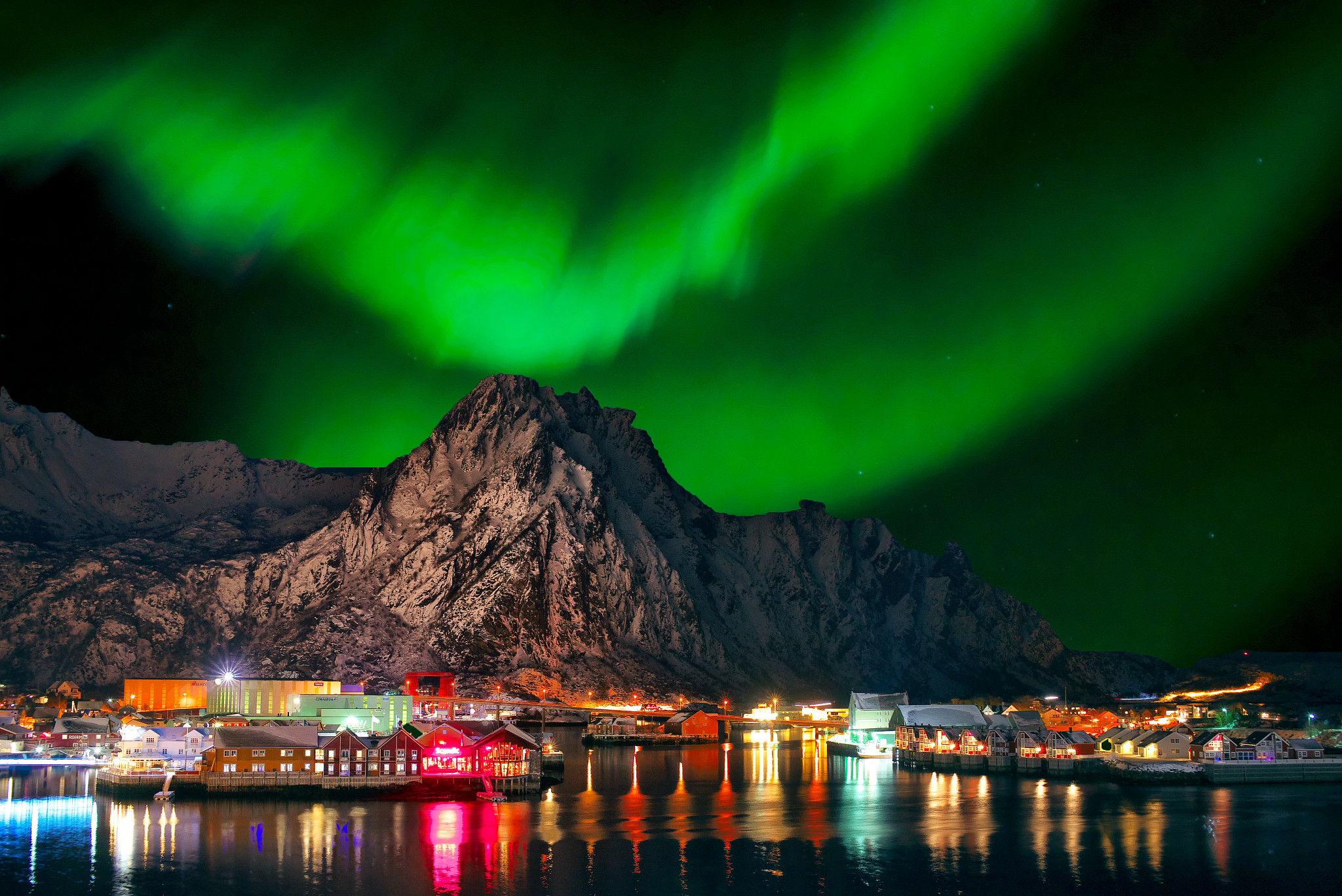 Dramatic show over the mountain and well-lit port in Norway