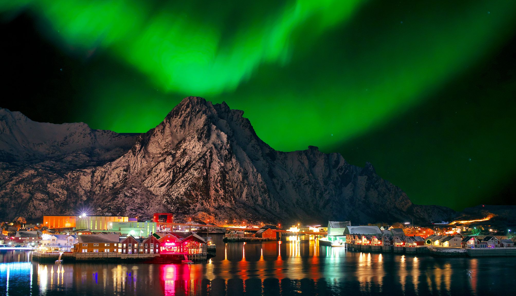 a guide to viewing the Northern Lights Dramatic show over the mountain and well-lit port in Norway