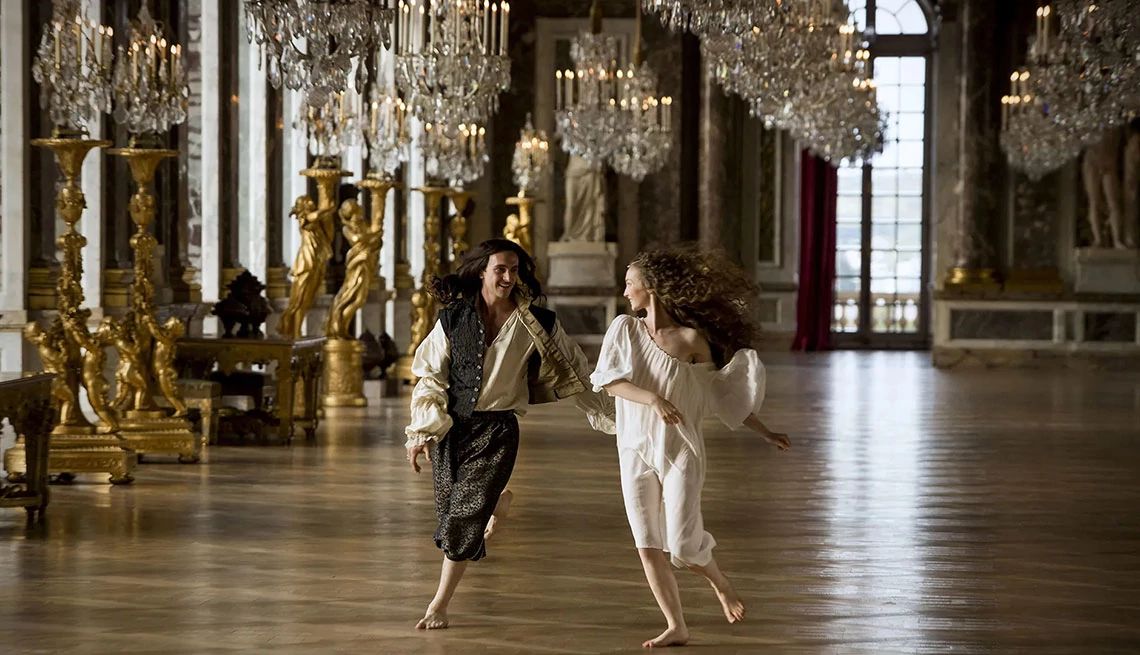 George Blagden and Alexia Giordano running around barefoot in an empty room in the TV series Versailles