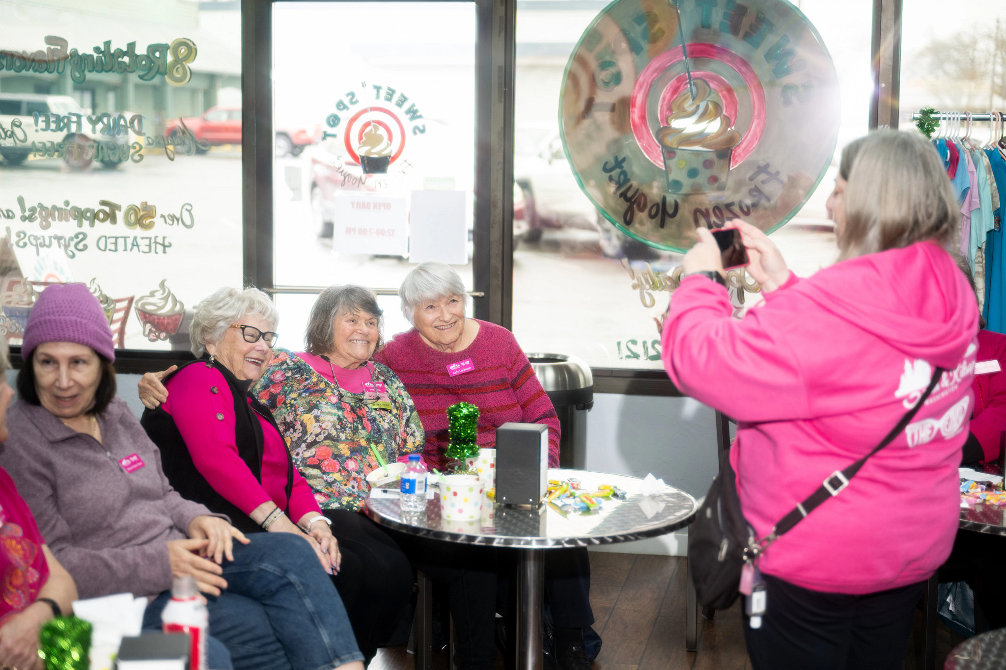 barb thibert standing to take a photo of a group of smiling older women at an ethels gathering