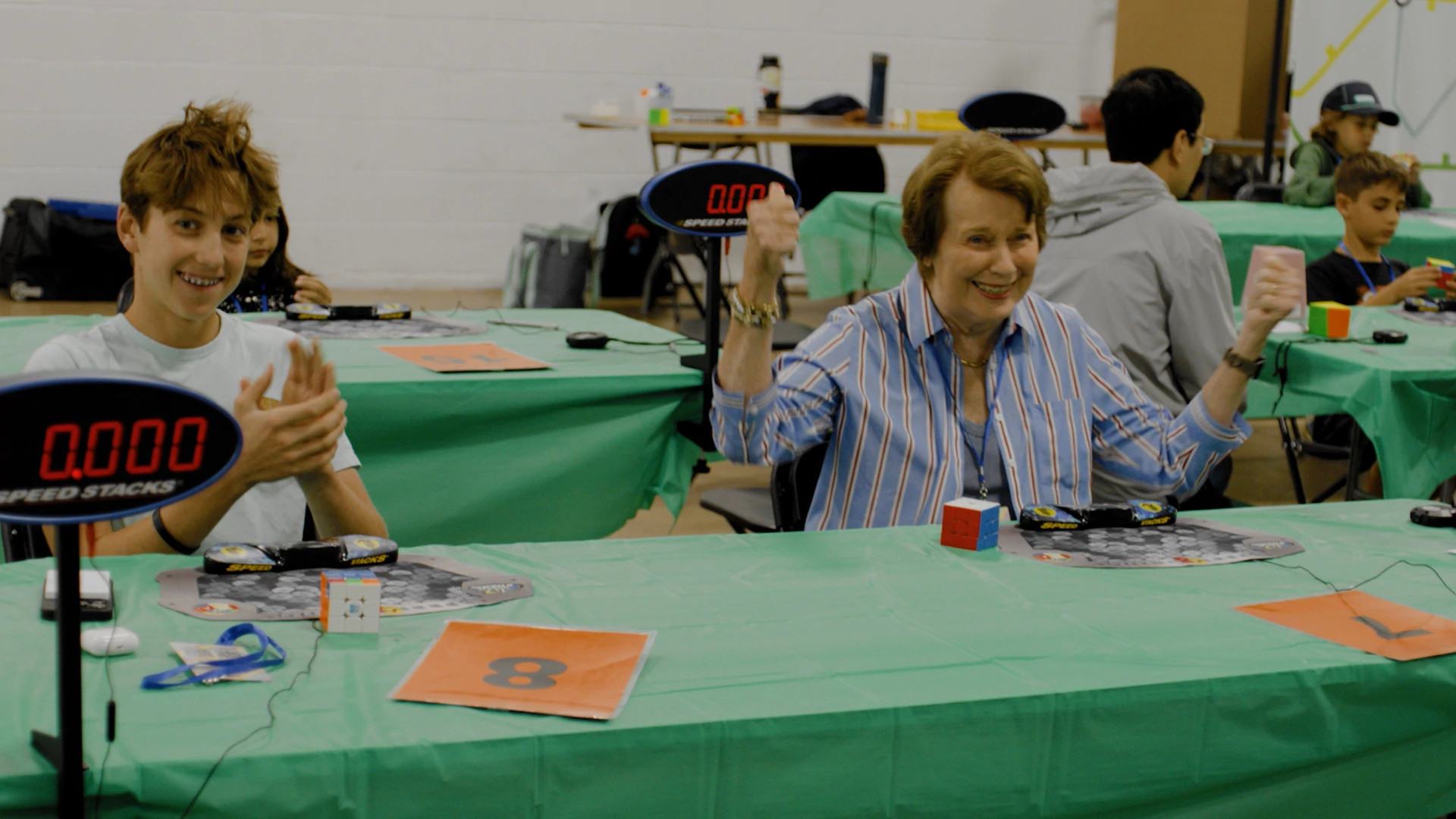 A photo shows Anne Squadron and her grandson Theo at the Mid-Atlantic Speedcubing Competition.