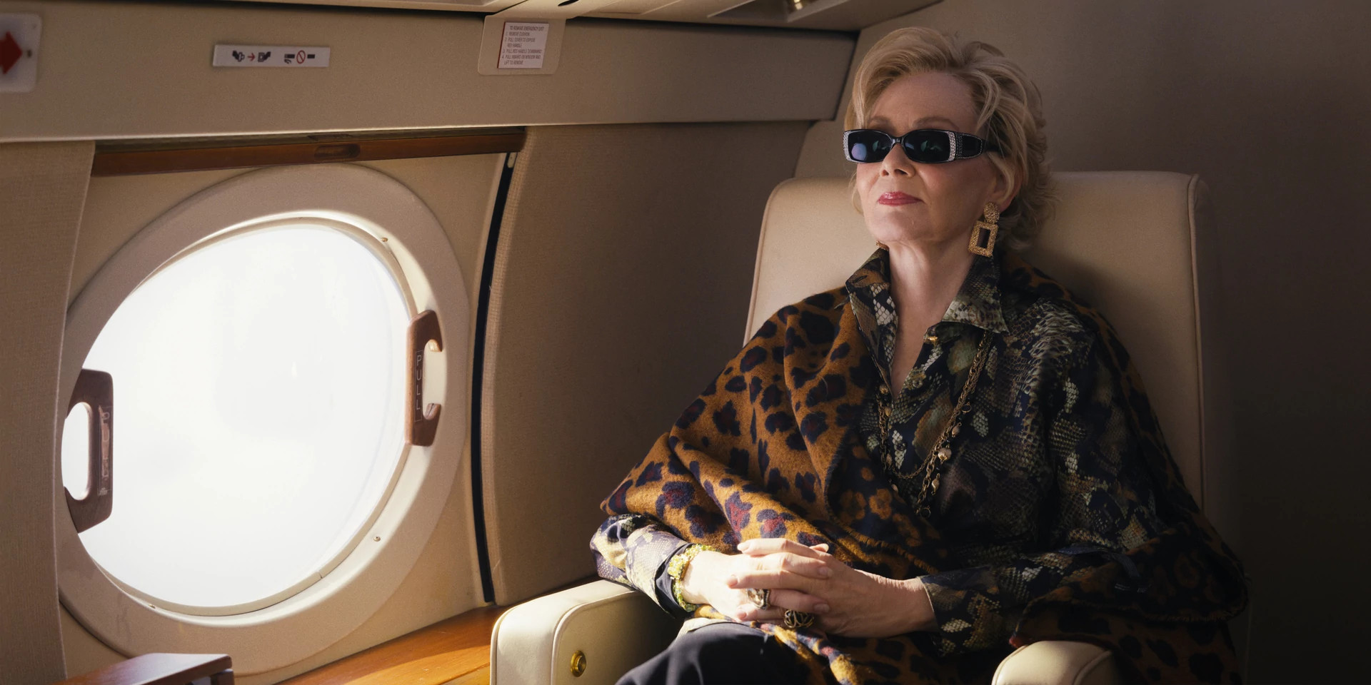 Jean Smart in a seat on a plane in a still from Hacks