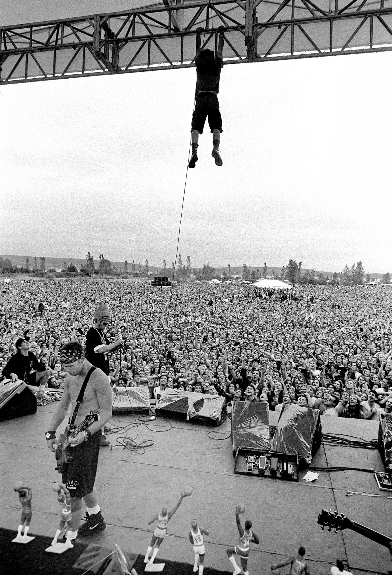 Eddie Vedder hangs from the rafters in Seattle's Magnuson Park at a concert in 1992 Eddie Vedder hanging from the rafters above a stage as huge crowd looks on