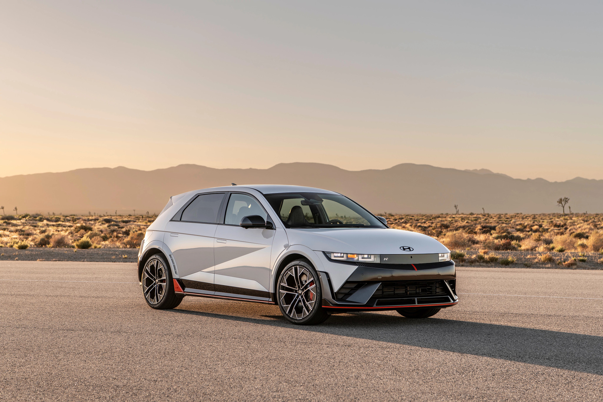 a gray four-door sedan slash compact s u v parked in the desert