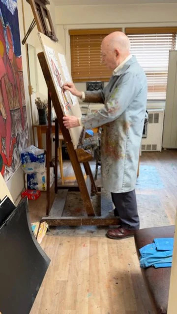 Ben Feldshuh painting at an easel inside a home