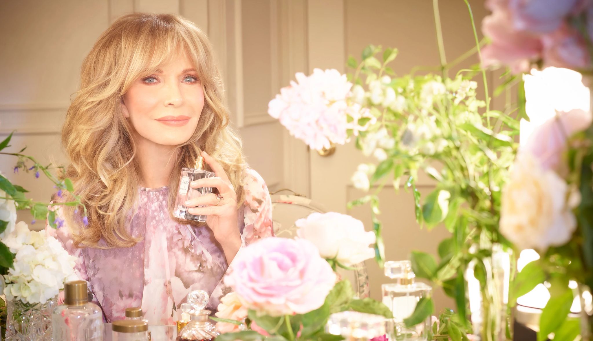Jaclyn Smith's new fragrance, Jackie Jaclyn Smith spraying perfume with flowers around her