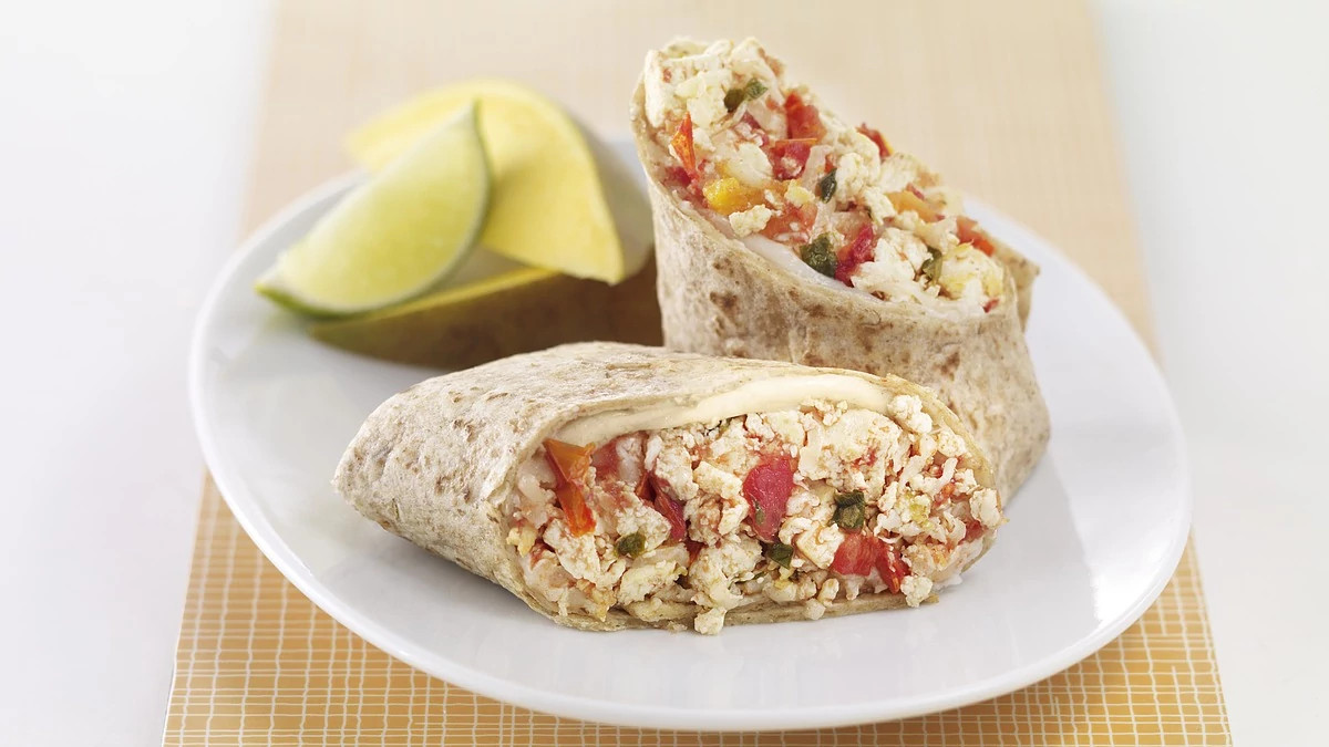 A close-up view of salsa-tofu breakfast burrito on a plate