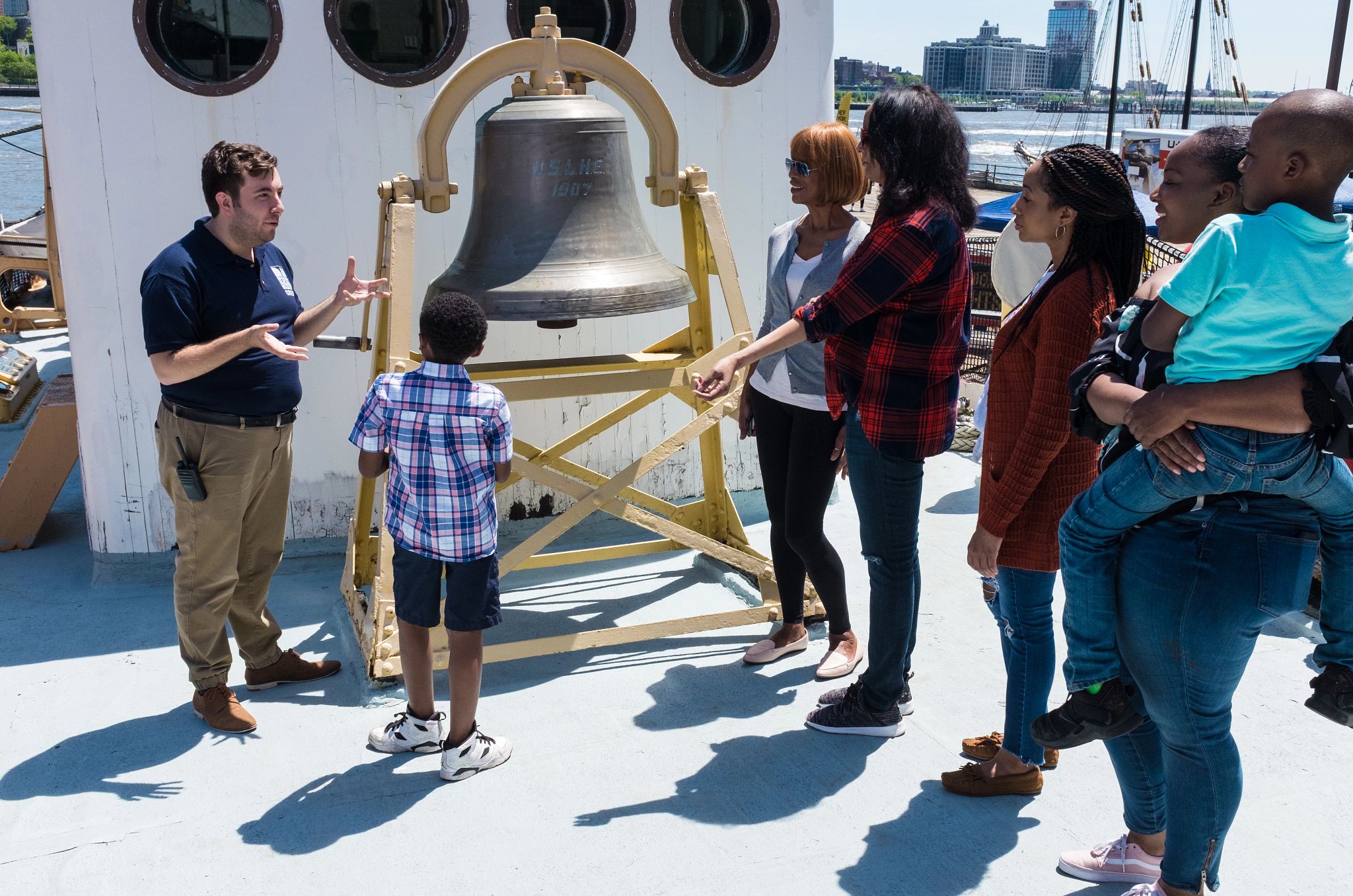 South Street Seaport Museum a group of people listen to a man talking near the South Street Seaport Museum’s bell