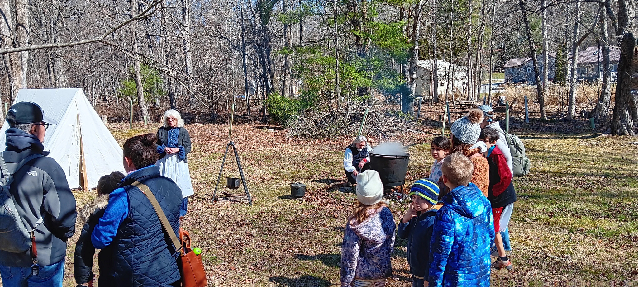 onlookers gather during an educational program at a maple farm