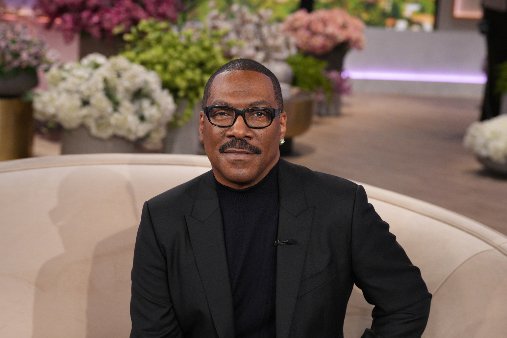 eddie murphy wearing a black jacket and a black shirt