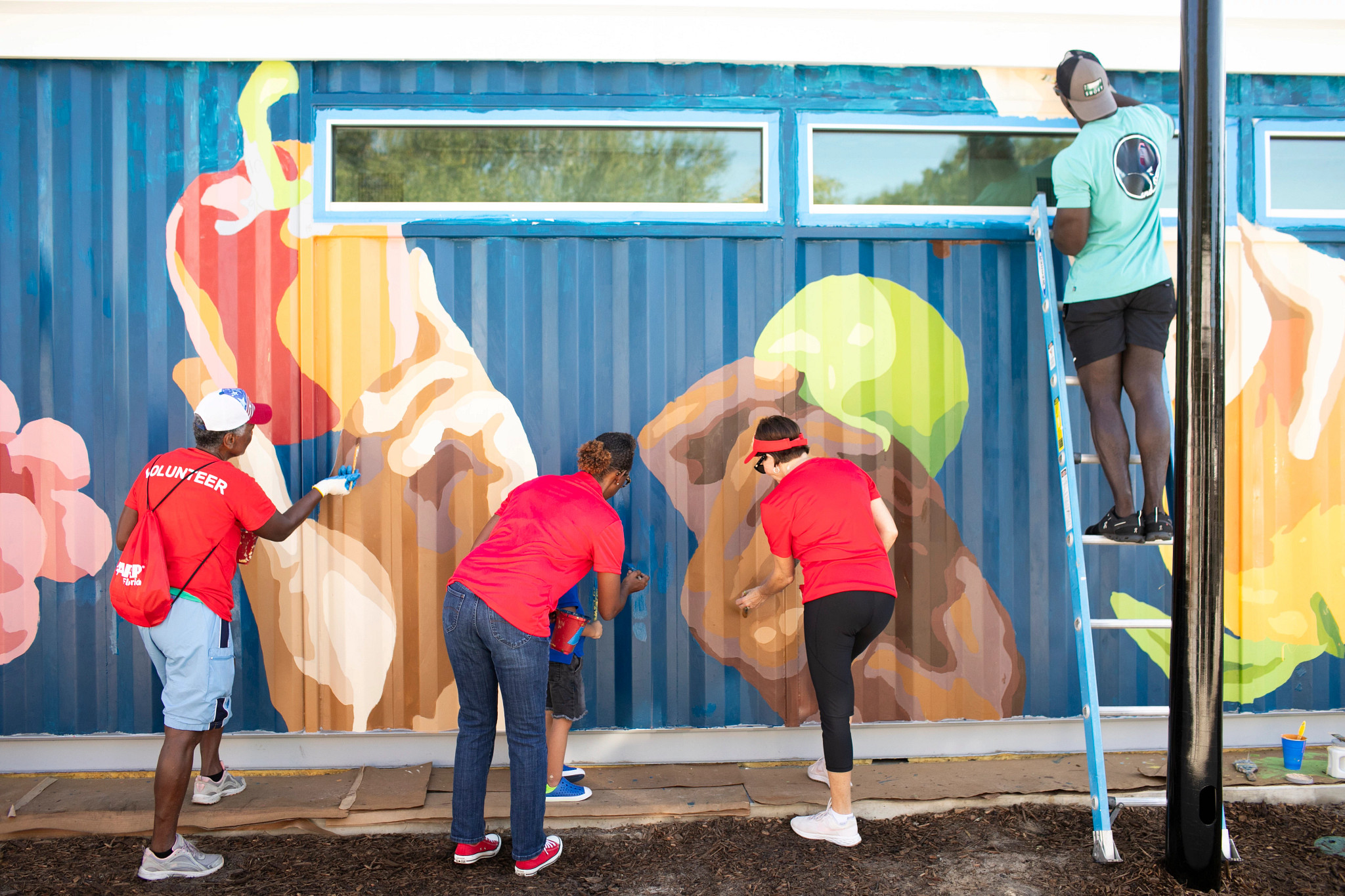 Tampa community volunteers painting a mural