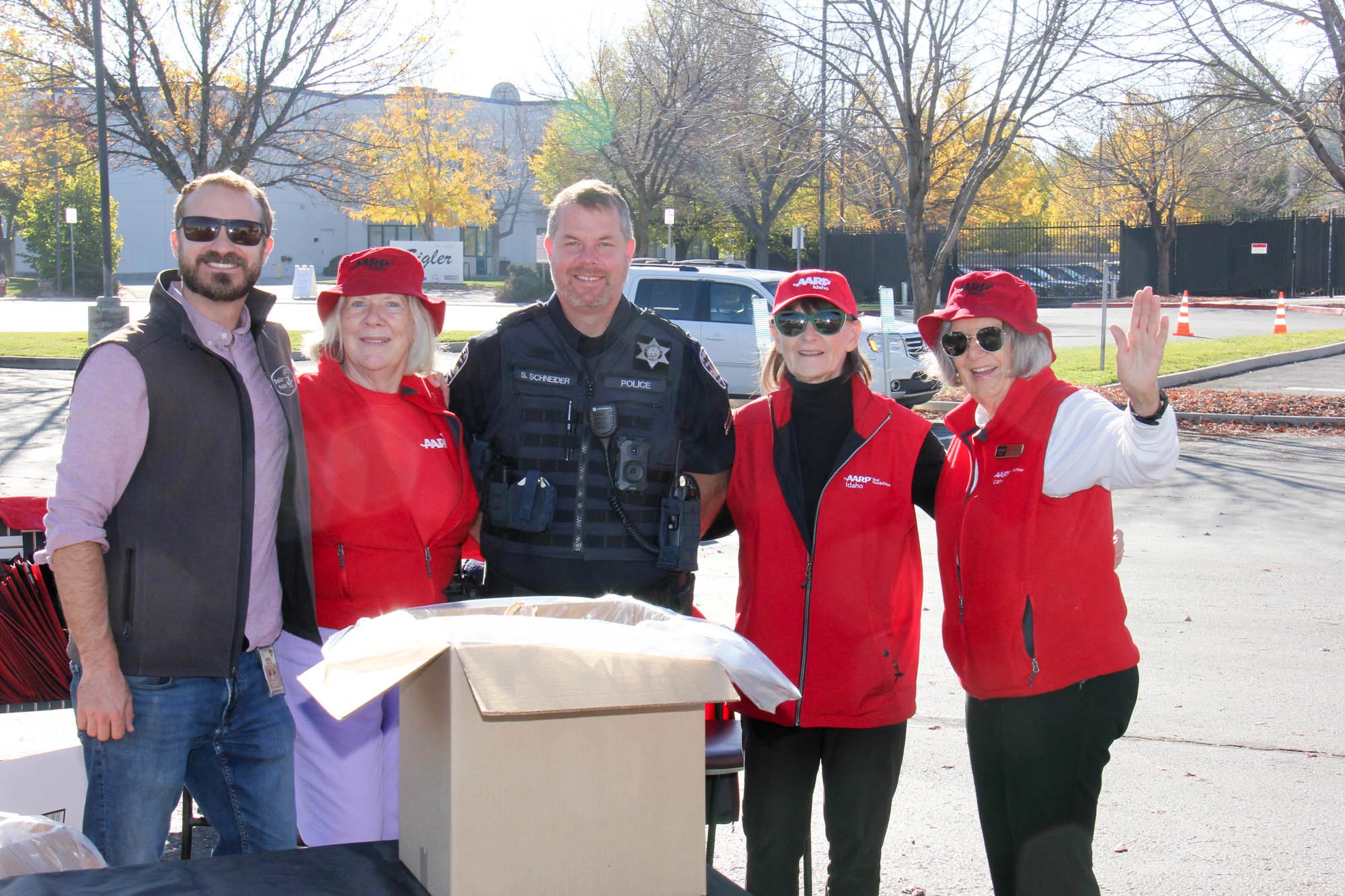 AARP Volunteers take group photo with police officer