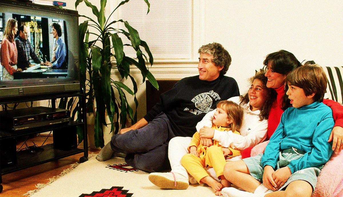 an animated gif in which a family is gathered around a vintage television set while still images from famous tv shows appear on the screen